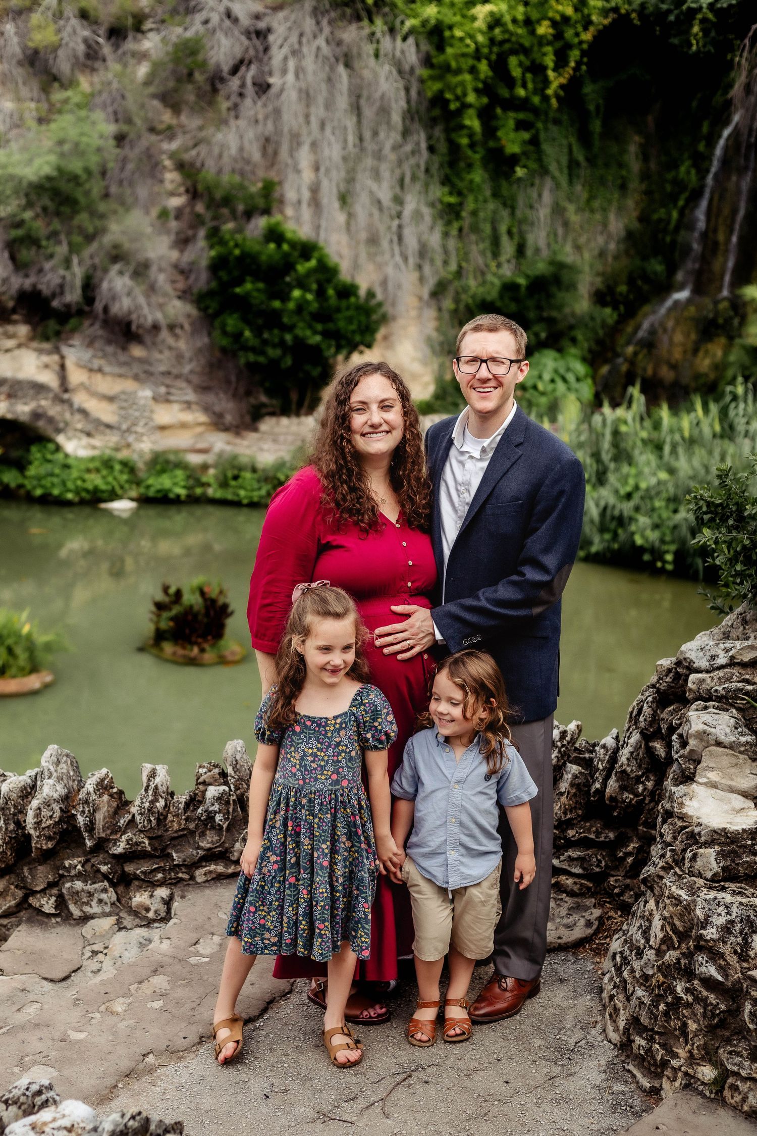 Family poses in front of Tea Gardens during maternity session
