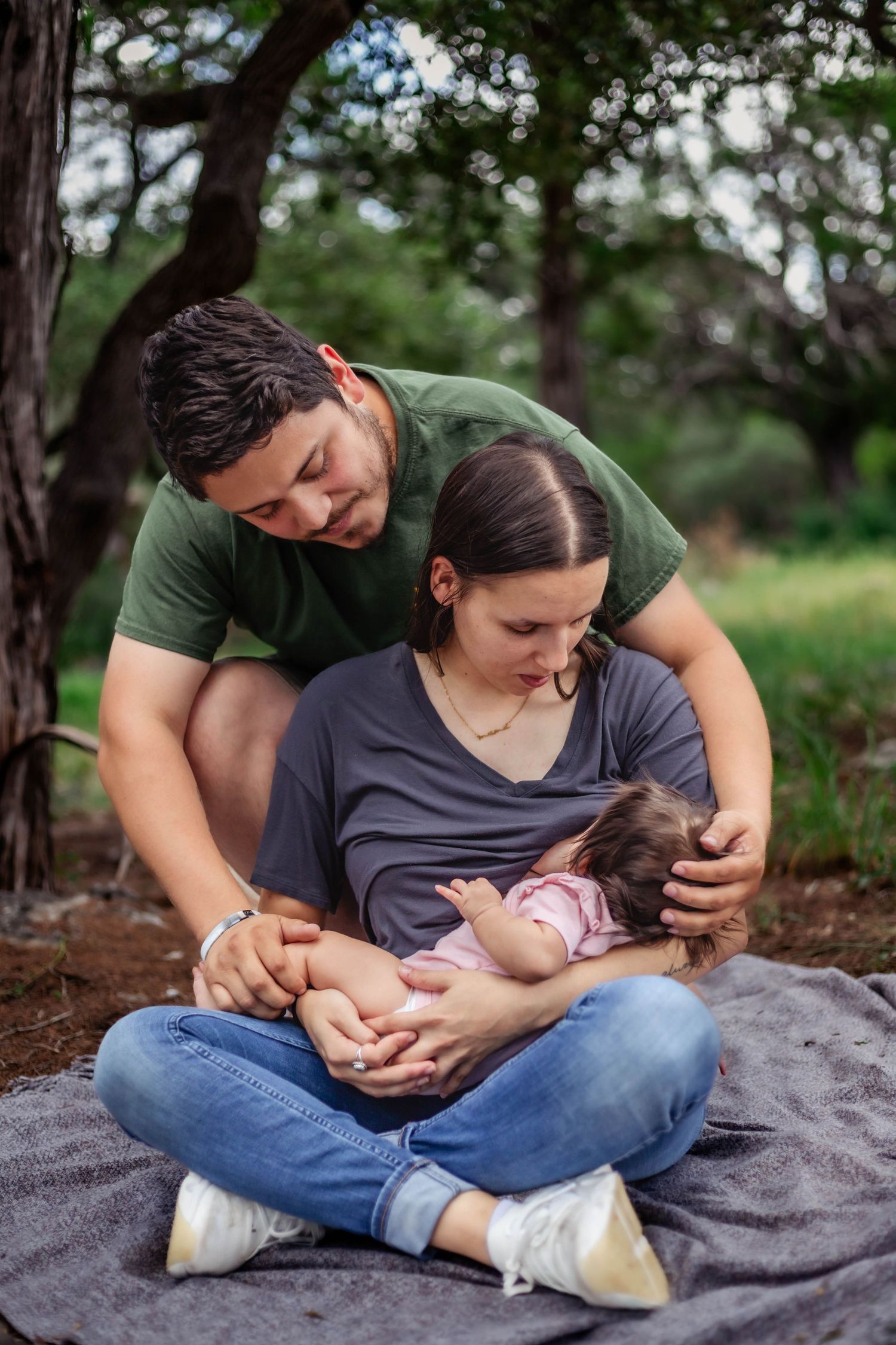 Mother and father look at baby while mother breastfeeds