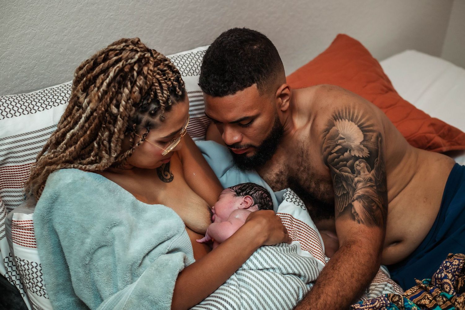 Mother and father look down at their newborn baby after free birth in New Braunfels home.