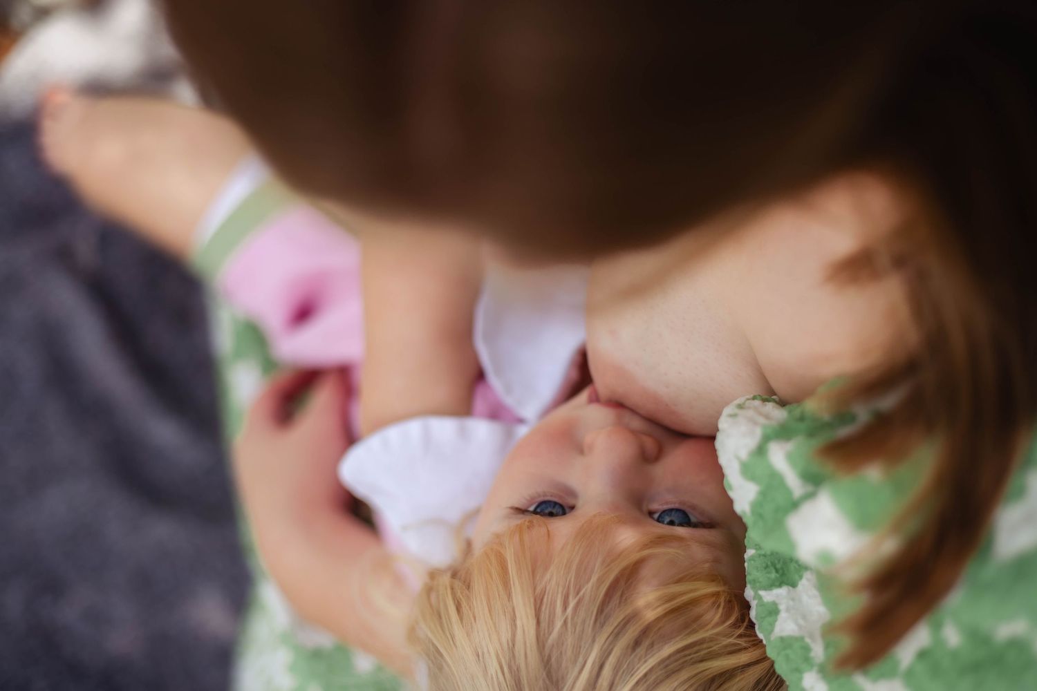 Nursing child looks up at mother