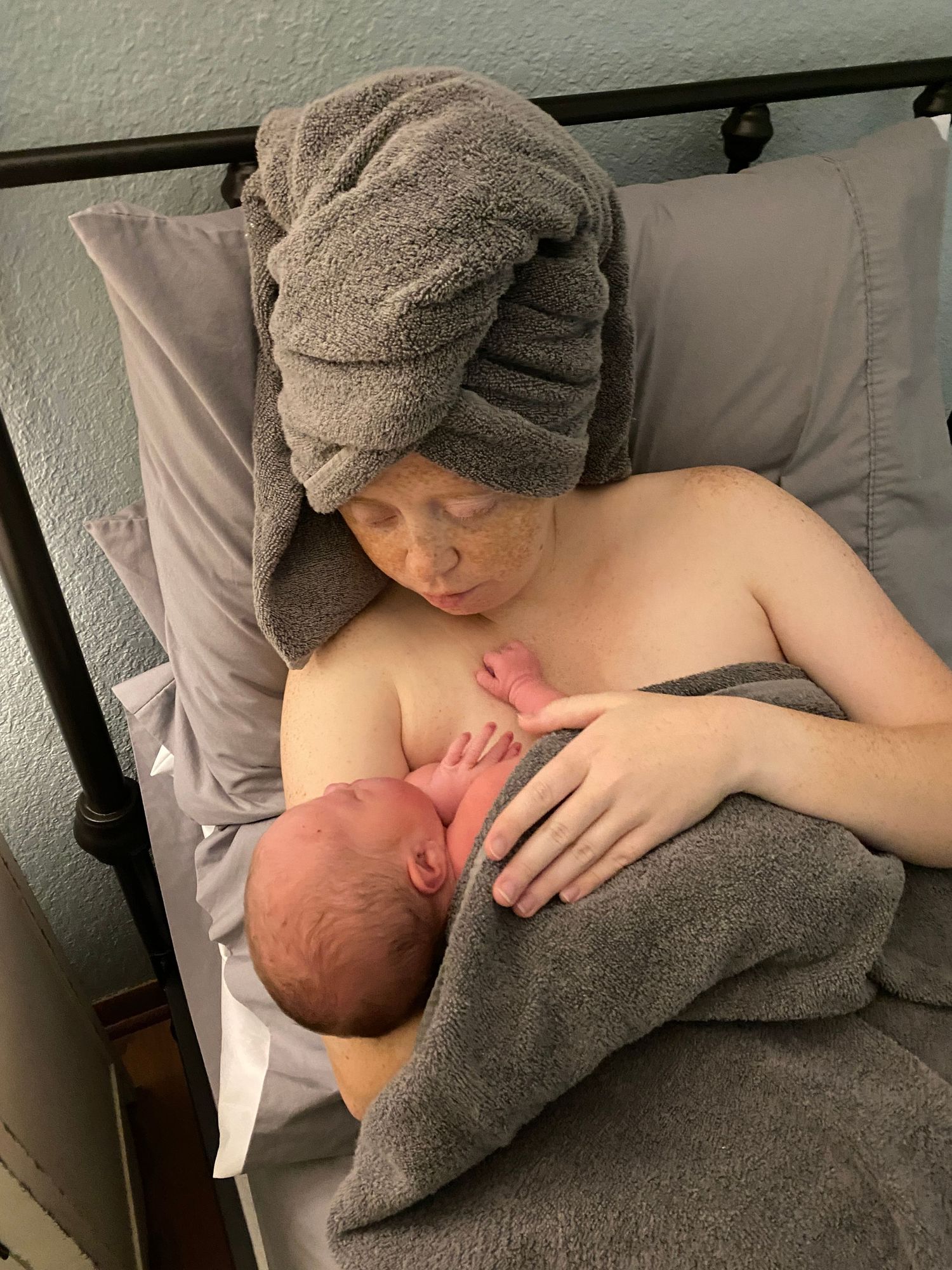Mother, Morgan the photographer of MZiegler Imagery & Doula Services, holds baby after delivery in birth center
