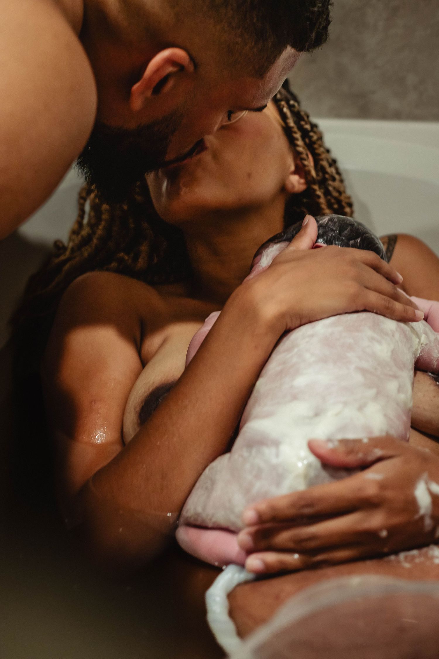 Husband and wife kiss after delivery of baby