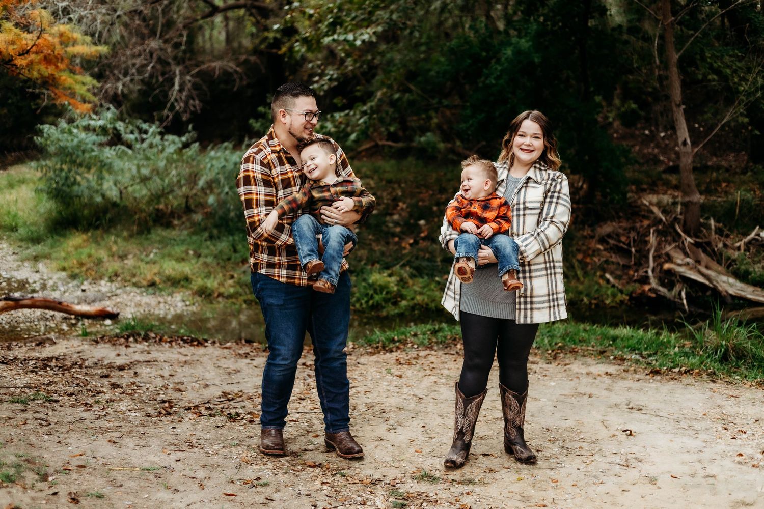 Mother and father hold their sons laughing during a family session