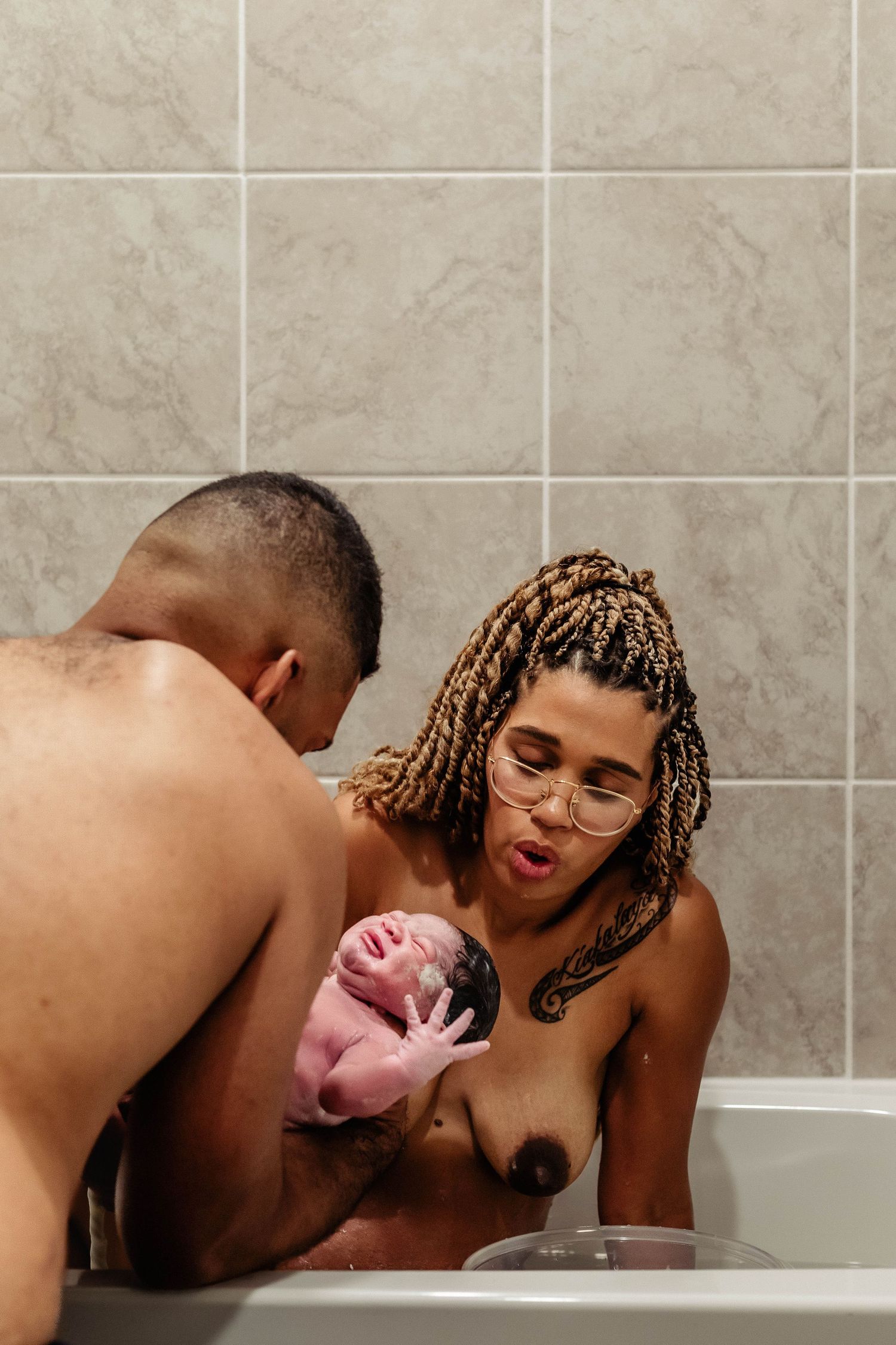 Father holds newborn baby while mother deals with contractions