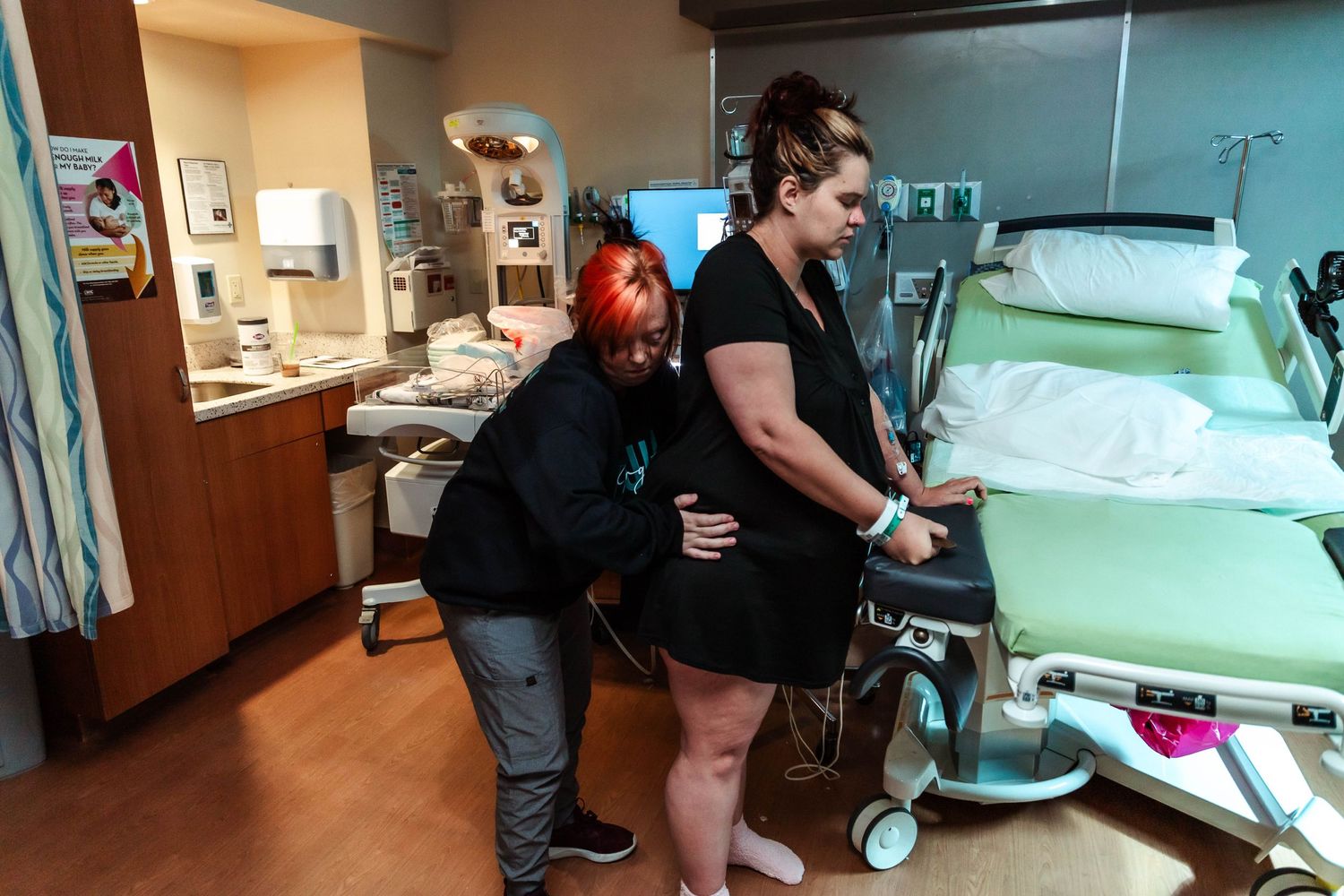 Doula does hip squeezes on mother in labor