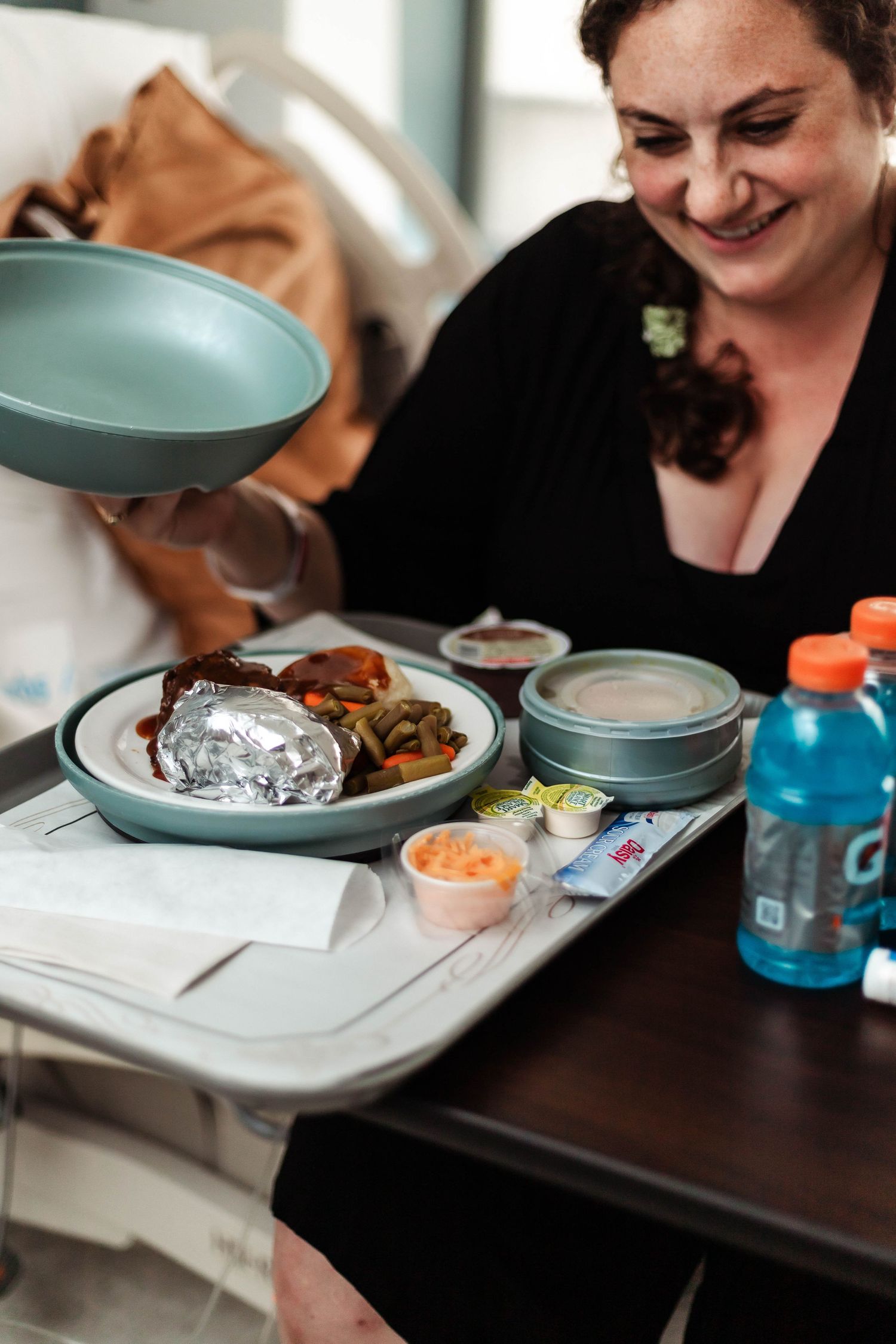 Laboring mother smiles at her food in hospital