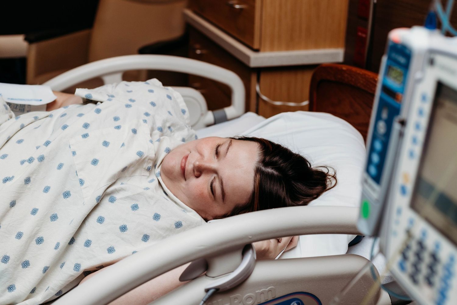 Laboring mother lays in the hospital bed smiling in New Braunfels hospital