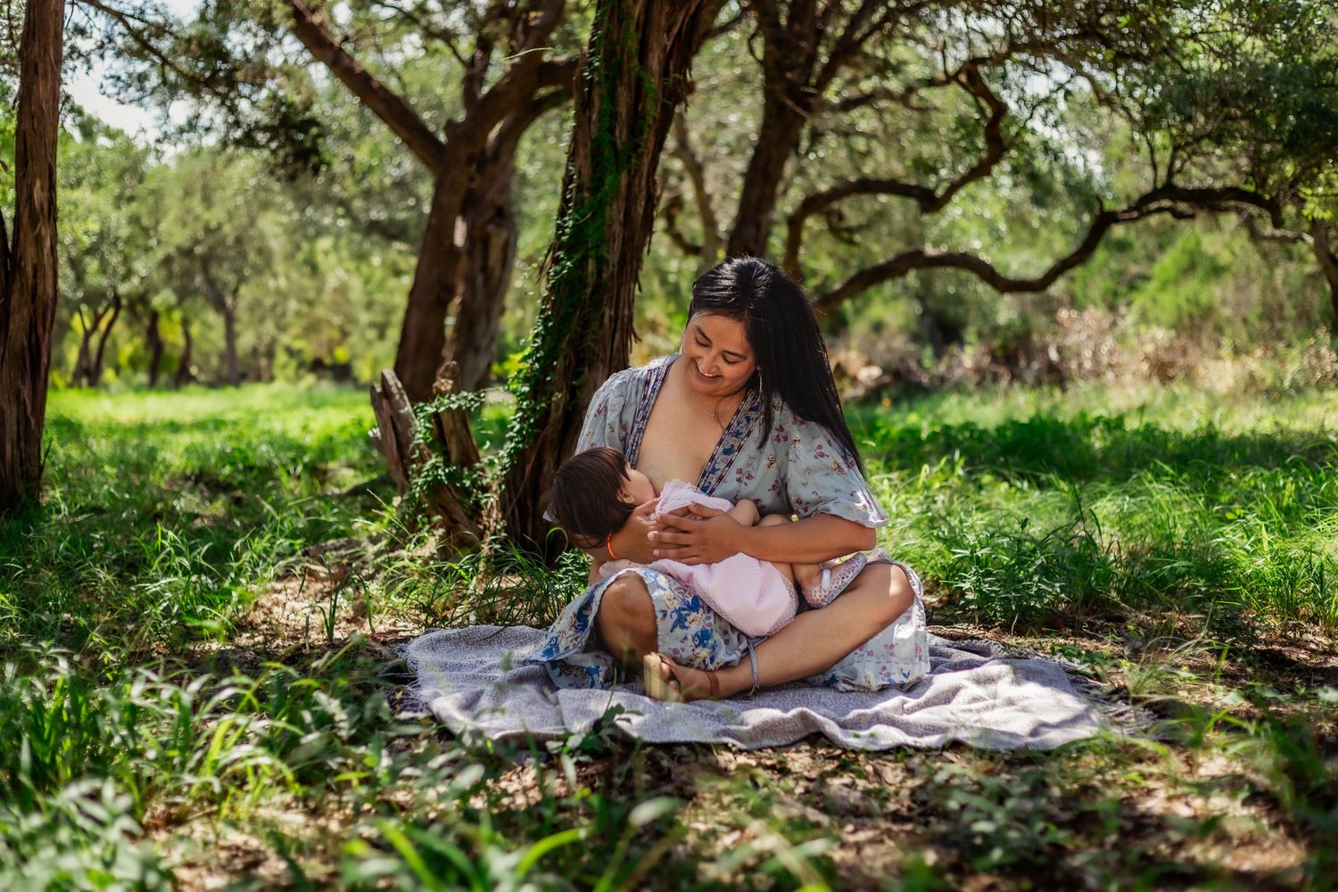 Mother nurses her older child in nature