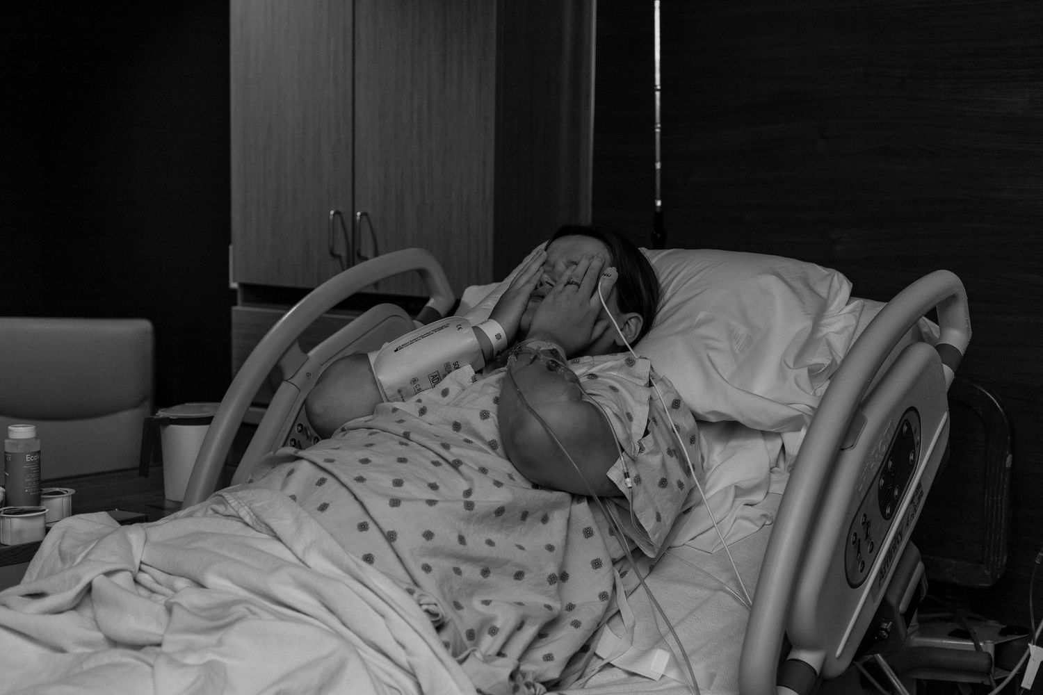 Laboring woman rubs face after being told her labor isn't progressing well and needs to be a cesarean