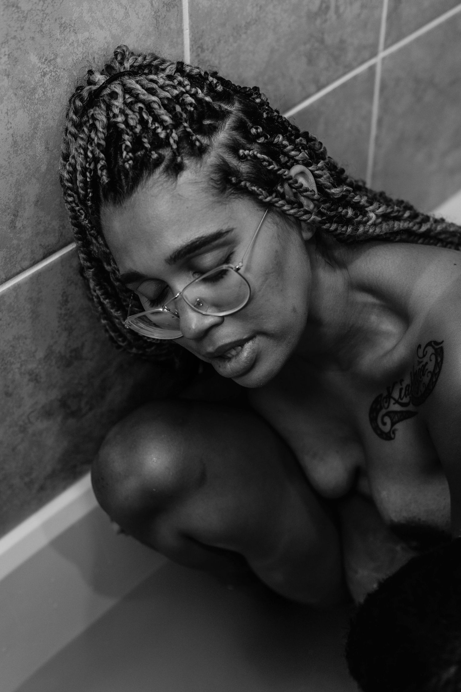 laboring mother leans against bathtub wall
