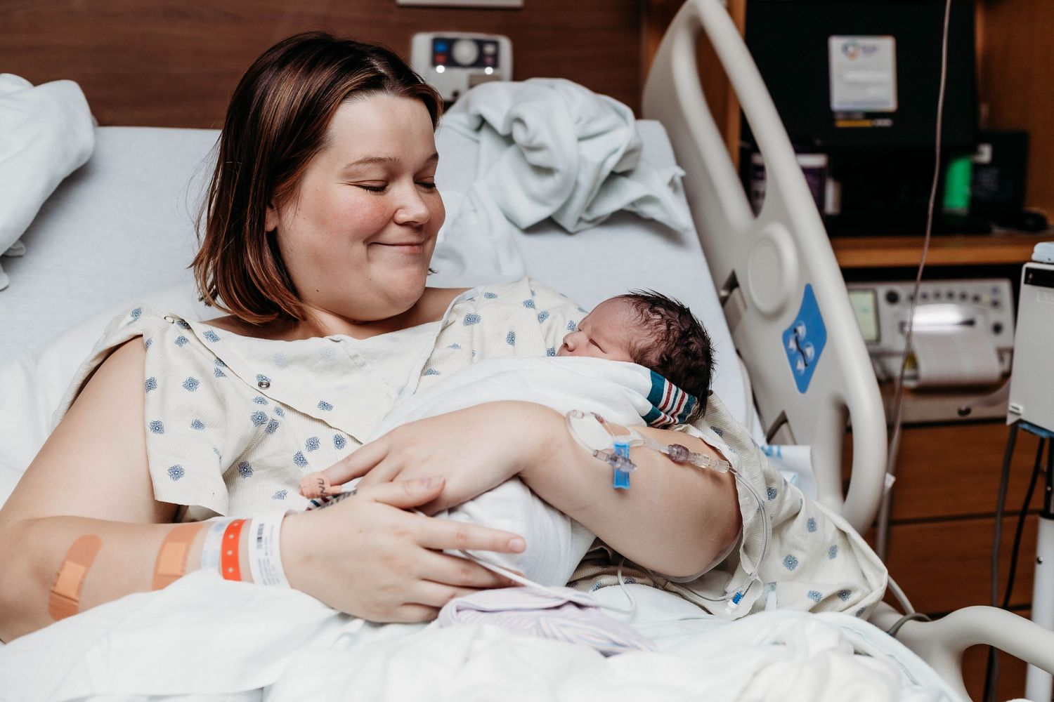 Mother holds newborn baby in hospital