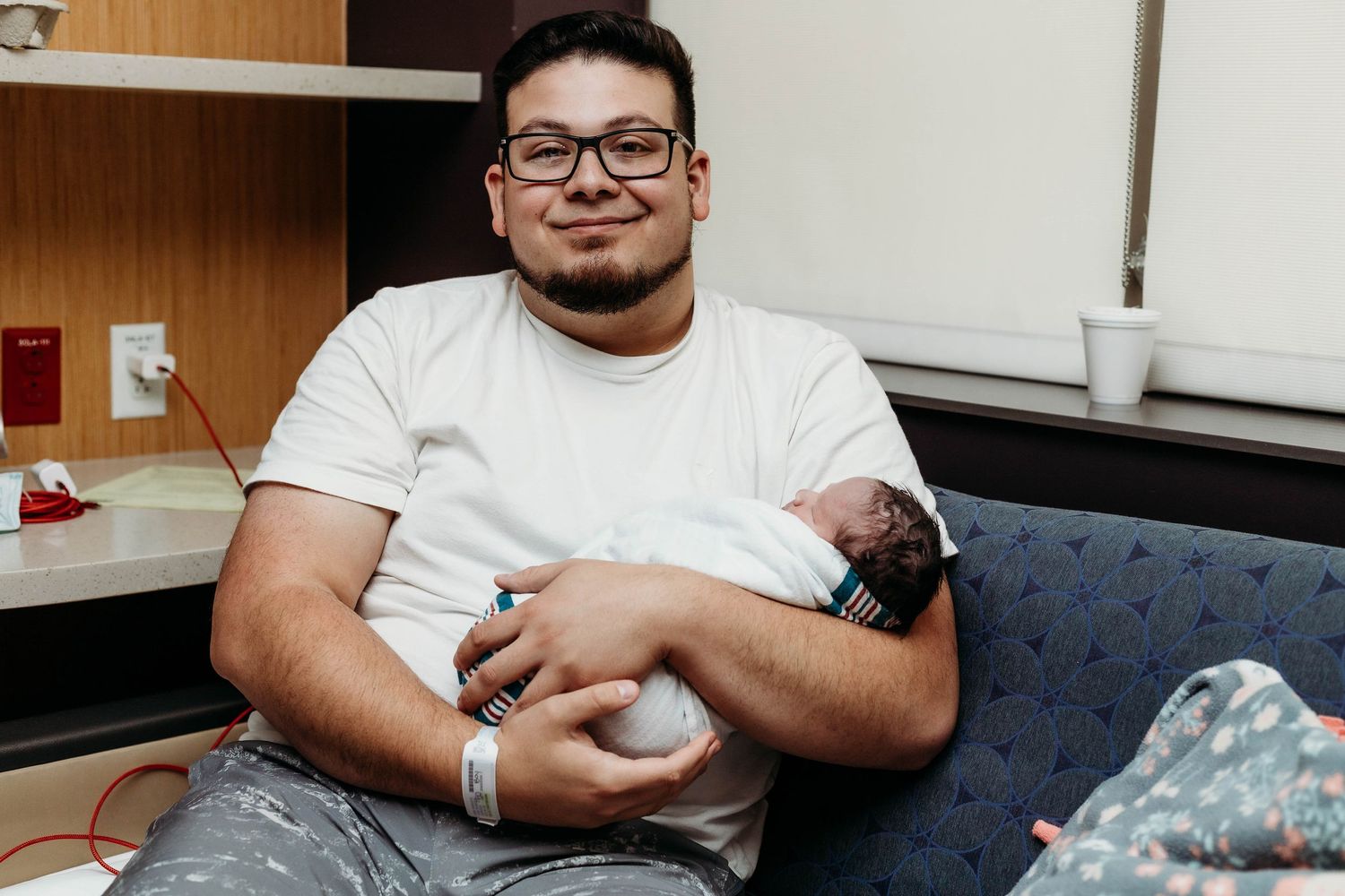 Father holds newborn baby in hospital