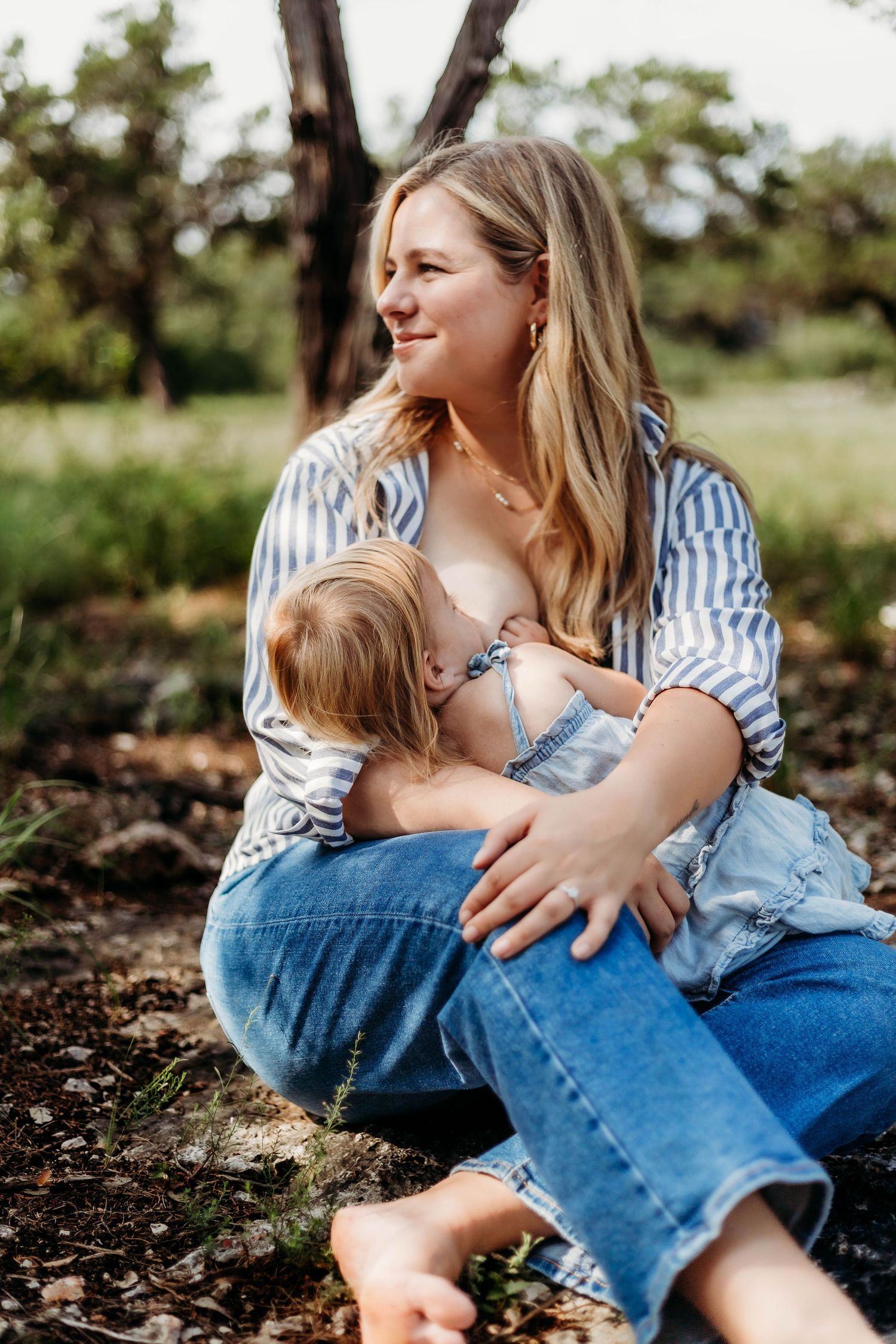 Mother nurses toddler outside