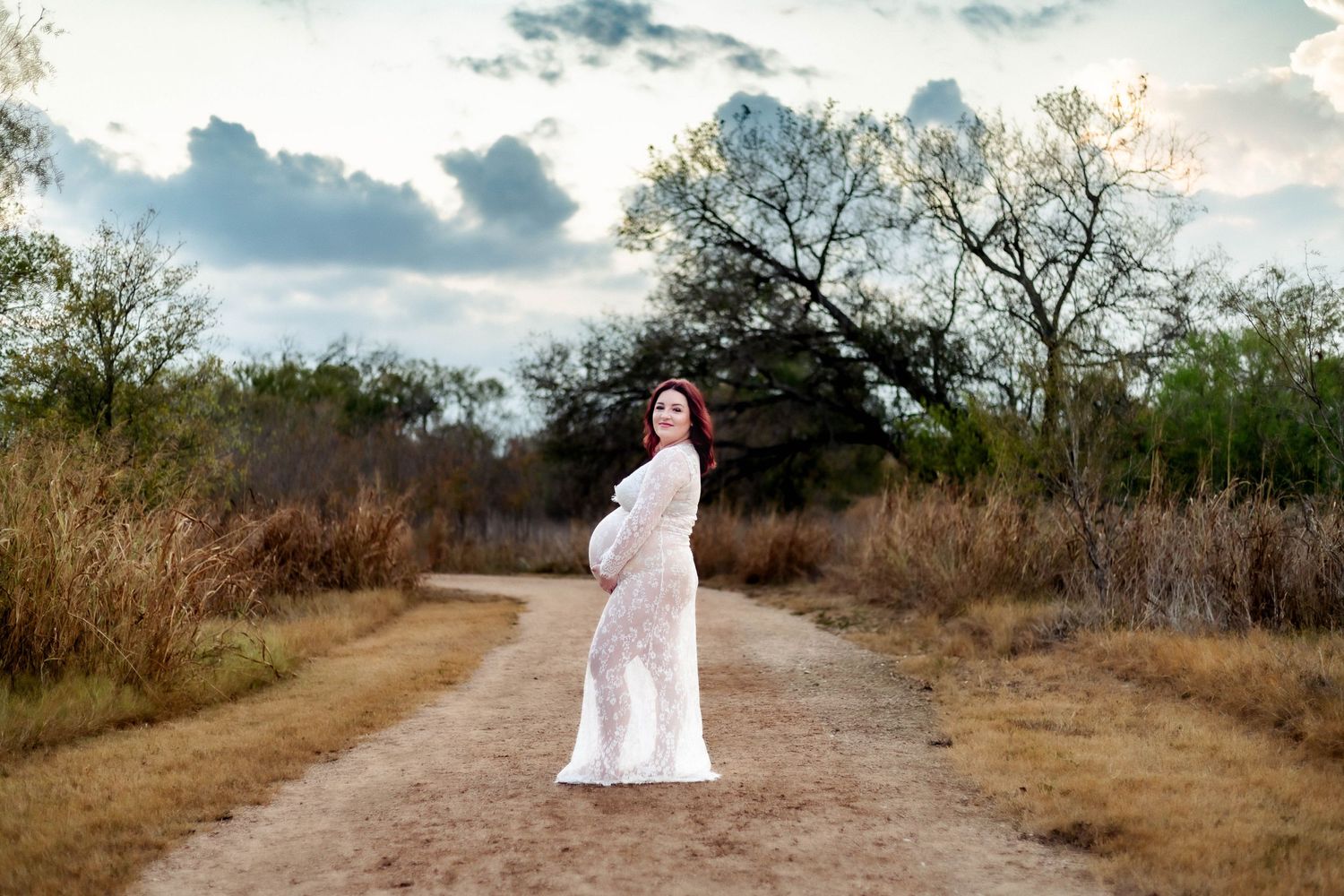 Pregnant mother poses on a dirt road during maternity session