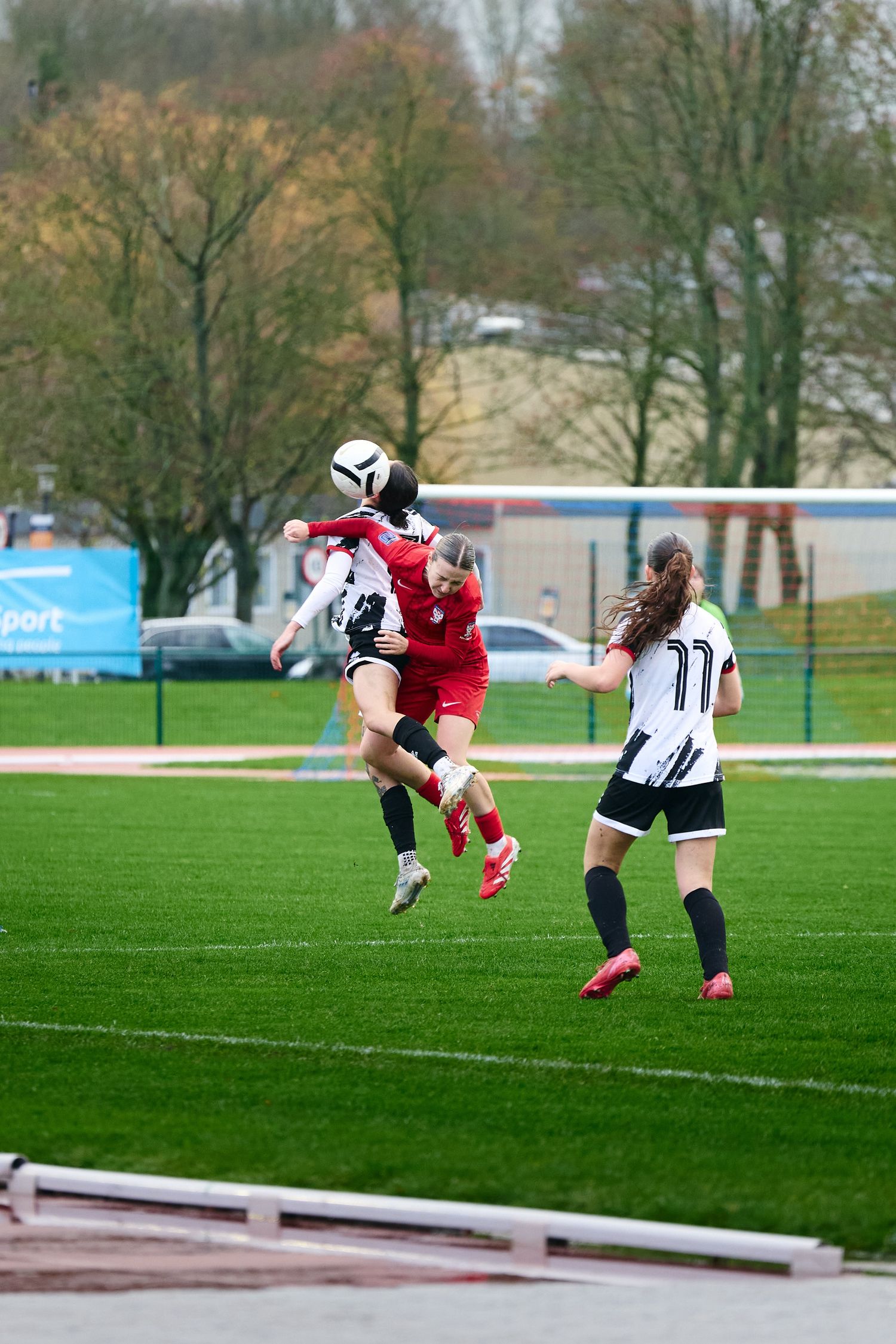 Soccer player performs an acrobatic bicycle kick on a green field during a match.