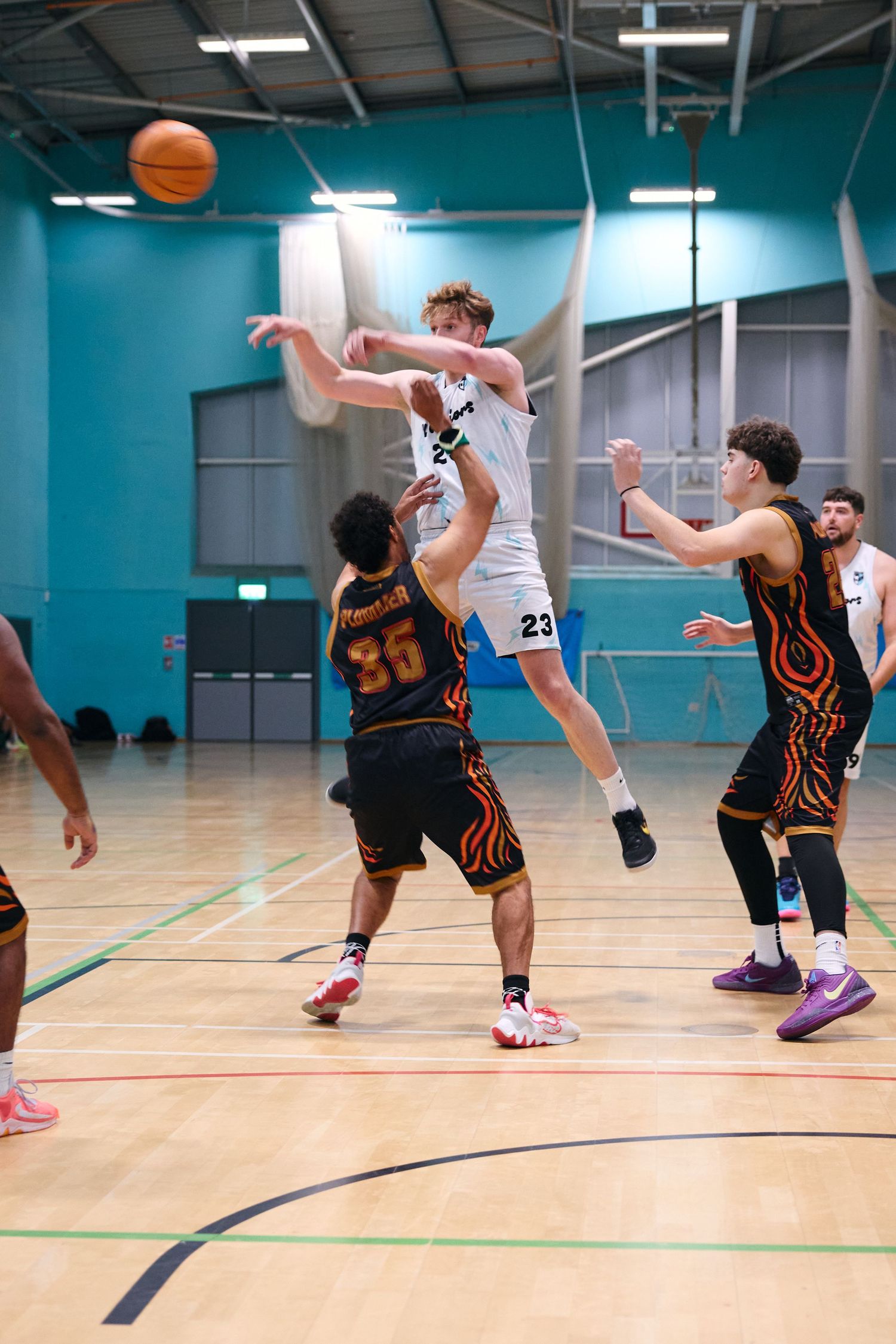 Basketball players in action during an intense indoor game sequence.