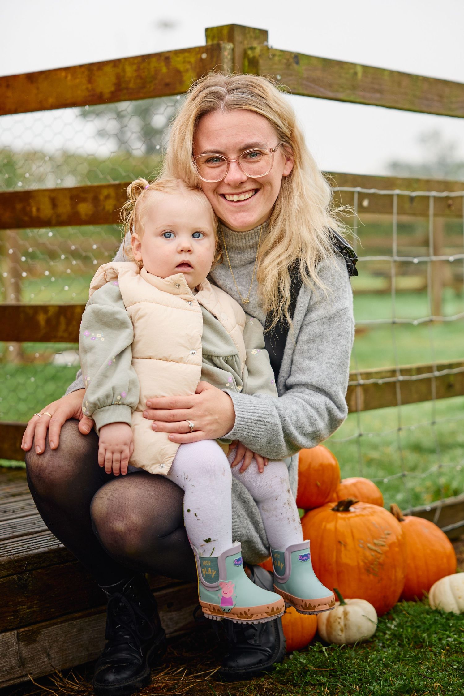 Autumn scene at pumpkin patch with people sitting on wooden bench.