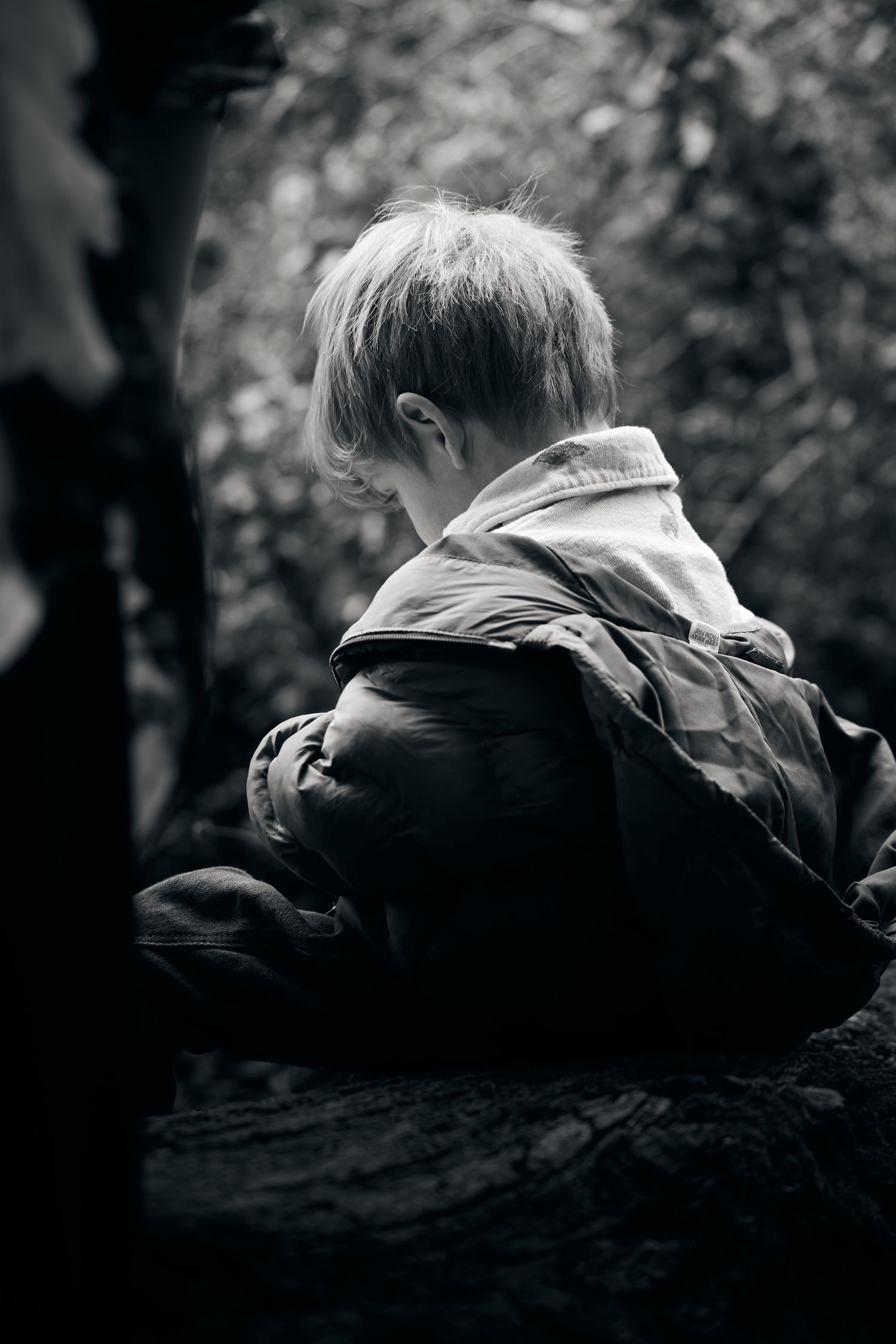 Artistic black and white close-up of person resting on natural surface.