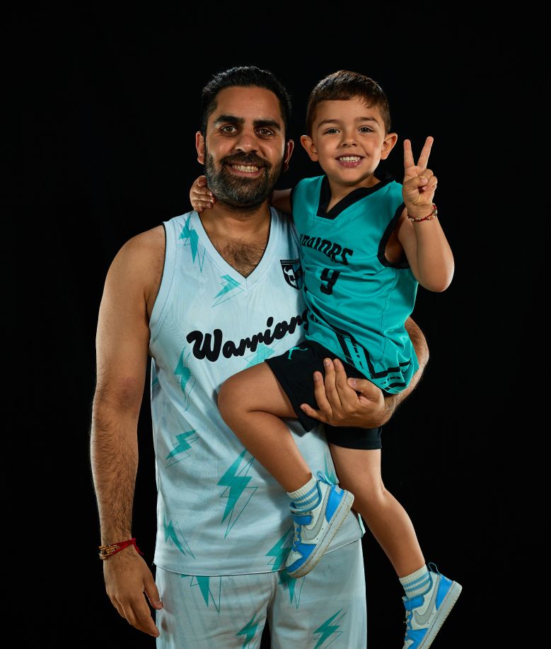 Two people in matching light blue Warriors jerseys pose playfully for a series of photos.