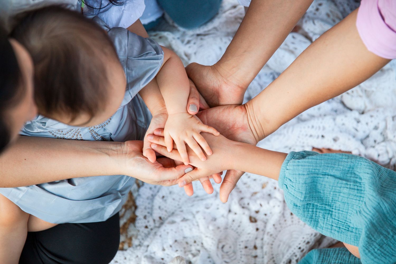 Close-up hands folded together in unity and support on light textured background. Family Photoshoot in Hong Kong