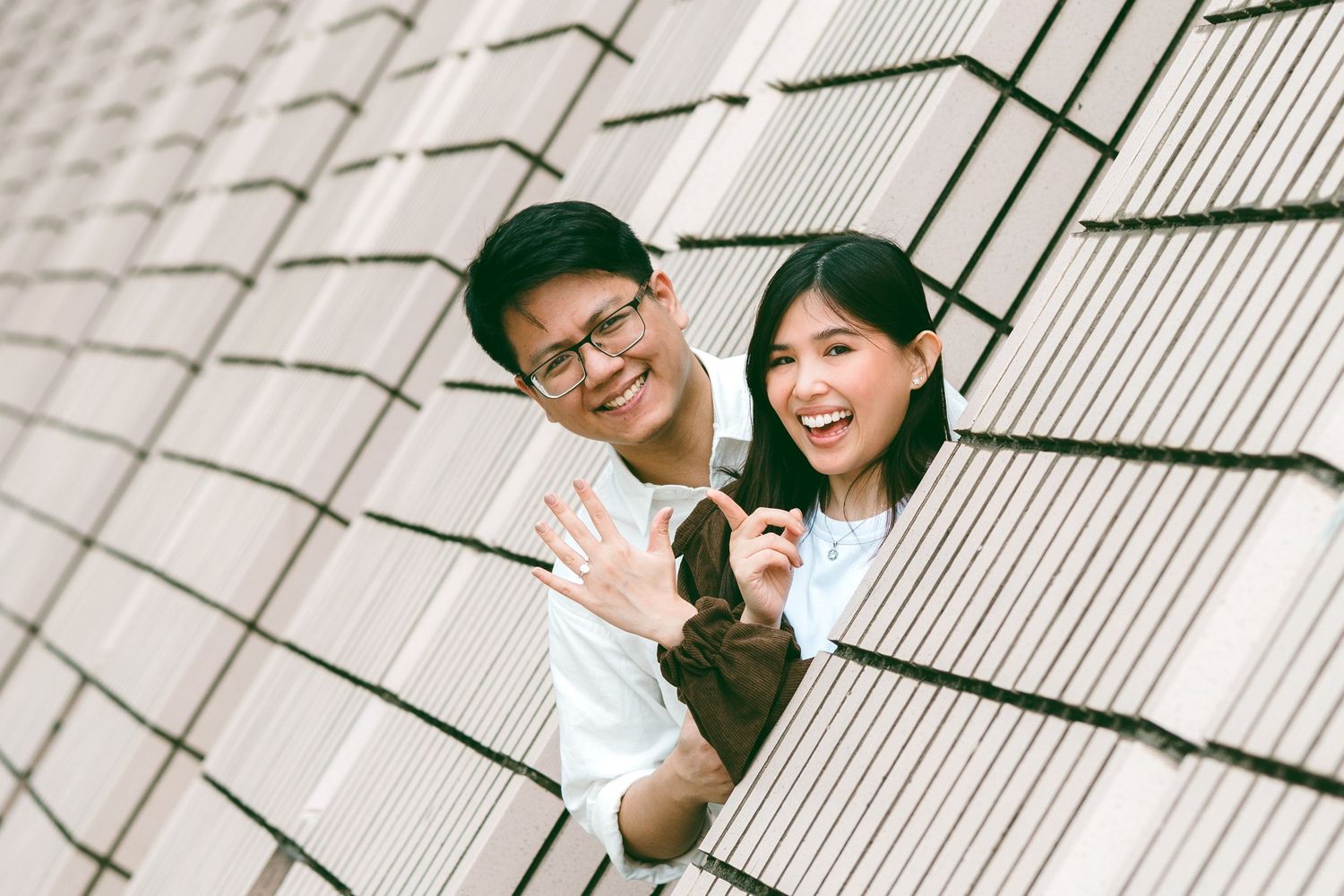 couple smiling and posing together in monochrome, architectural background. Couple Photoshoot in Hong Kong