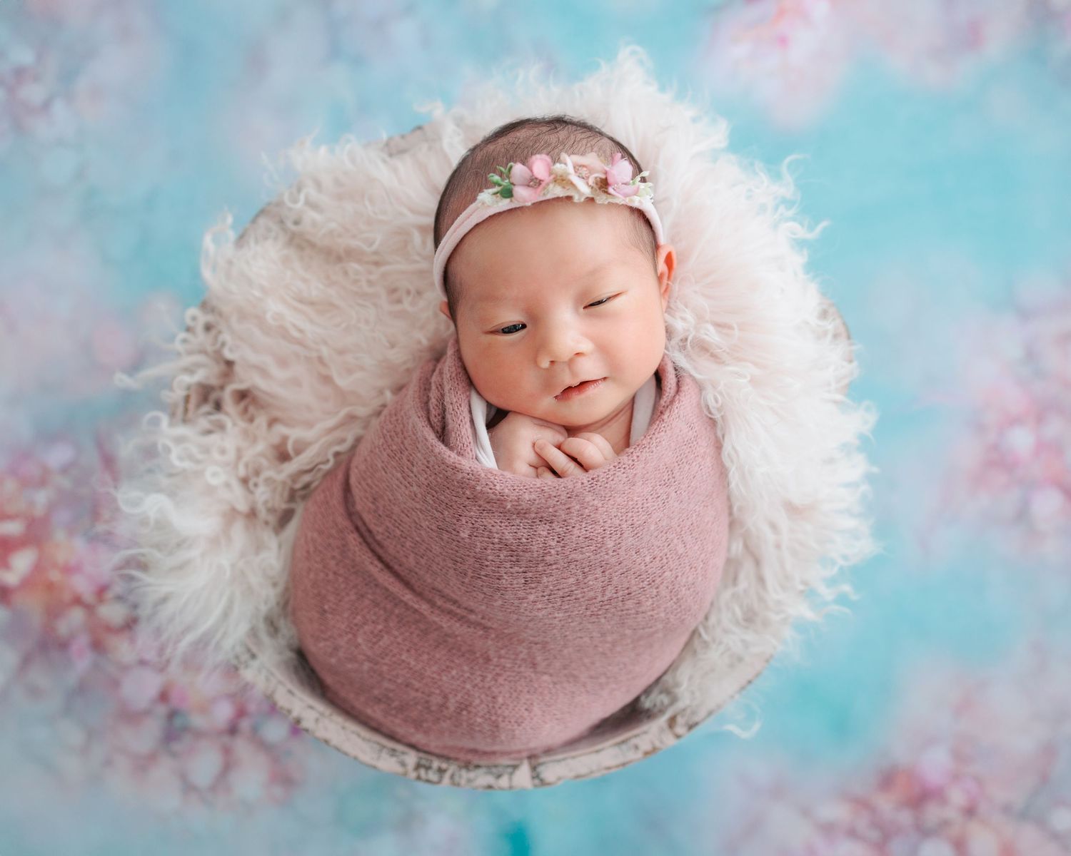 A set of five professional newborn photos with pink and blue tonal backgrounds featuring soft white fur and cozy wrappings. Newborn HK