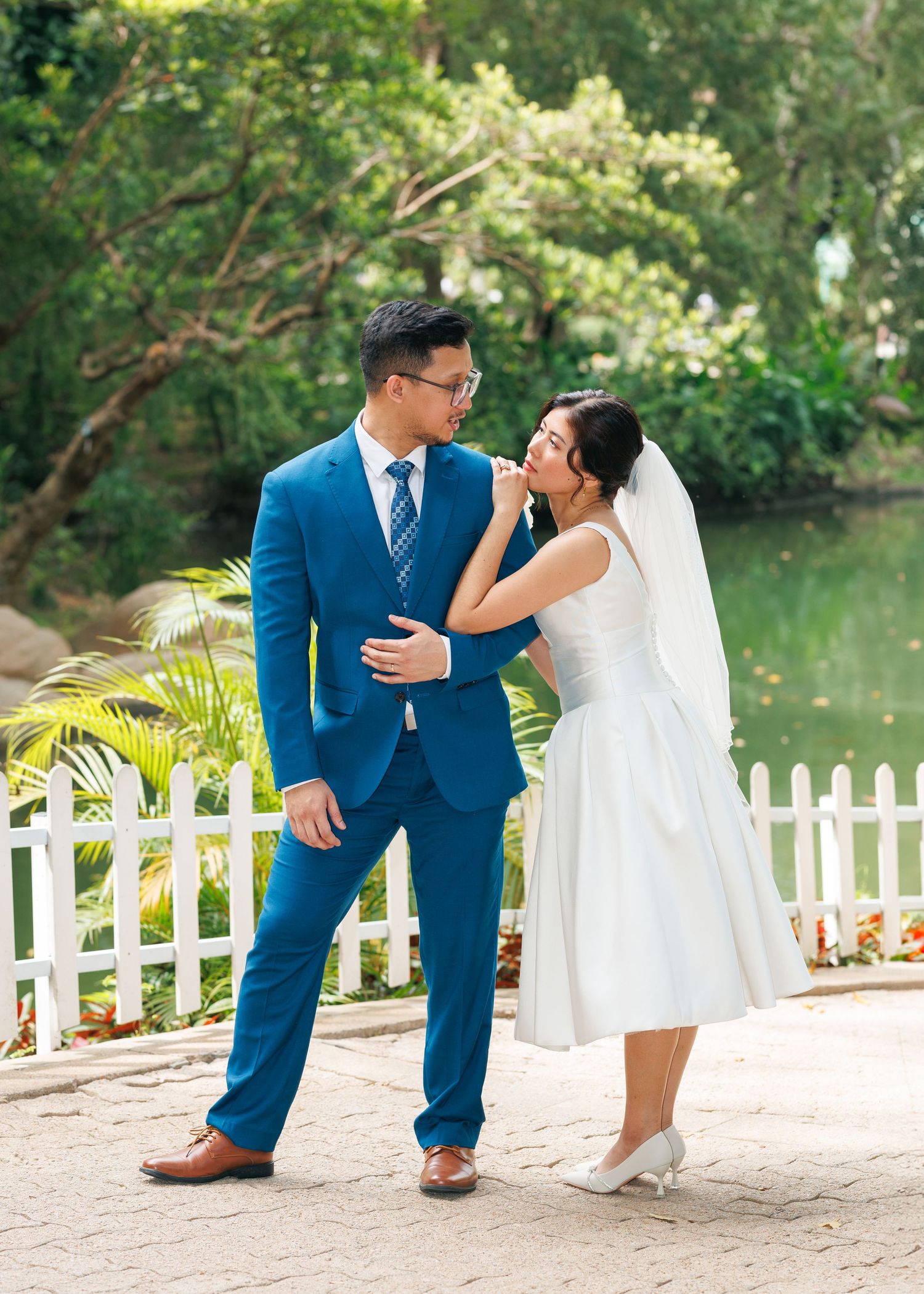 A couple shares a romantic moment on a white bridge overlooking a serene pond, Civil Ceremony in Hong Kong