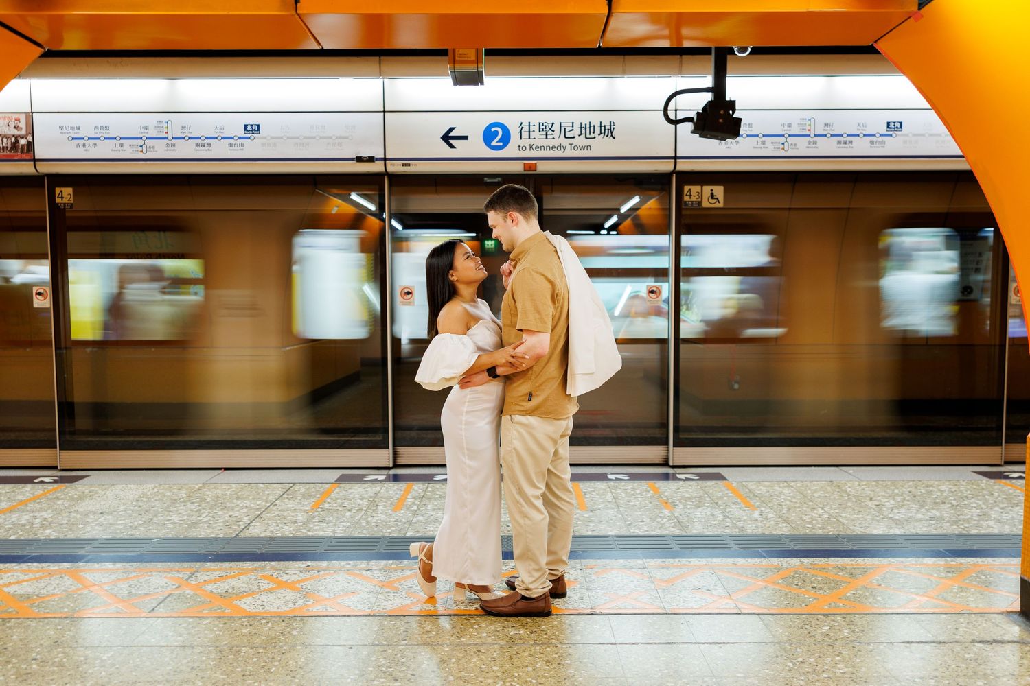 Couple  on a marble platform in a brightly-lit in Hong Kong MTR Station. Pre Wedding in Hong Kong