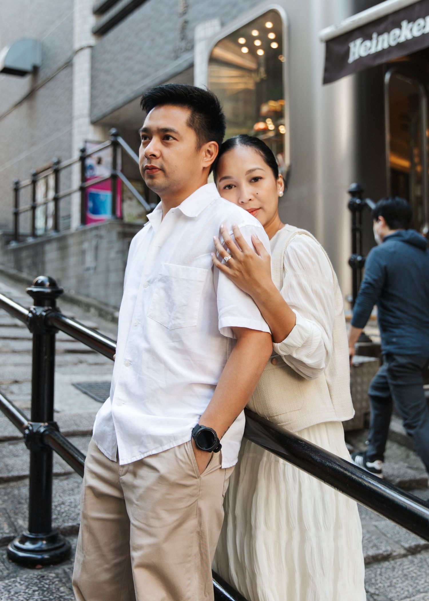 A couple shares romantic moments together on urban steps while wearing coordinated white and beige outfits. Couple Photoshoot in Central, HK