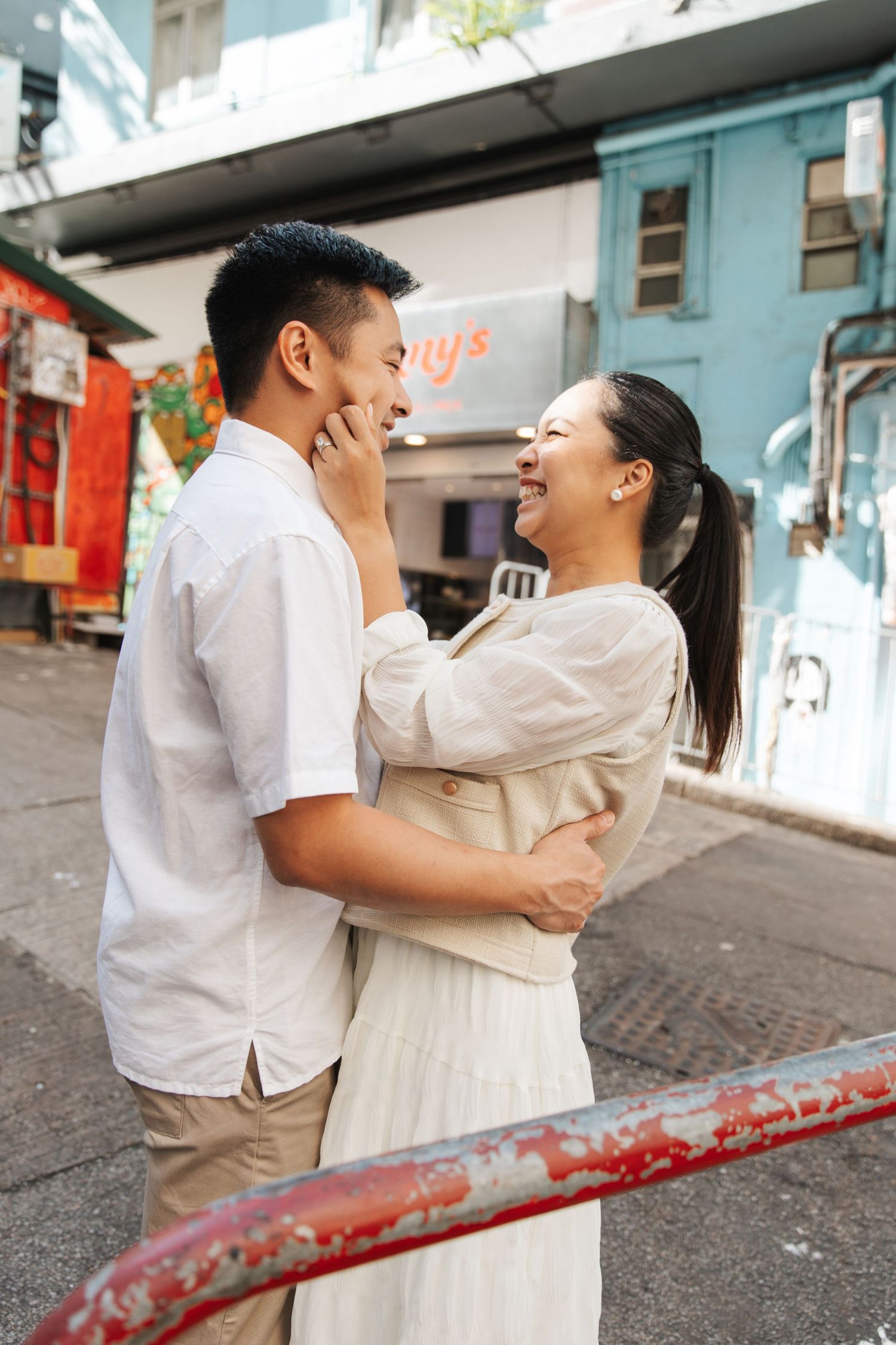 A couple embraces on a city street in Hollywood Road. Couple Photoshoot in Central, Hong Kong