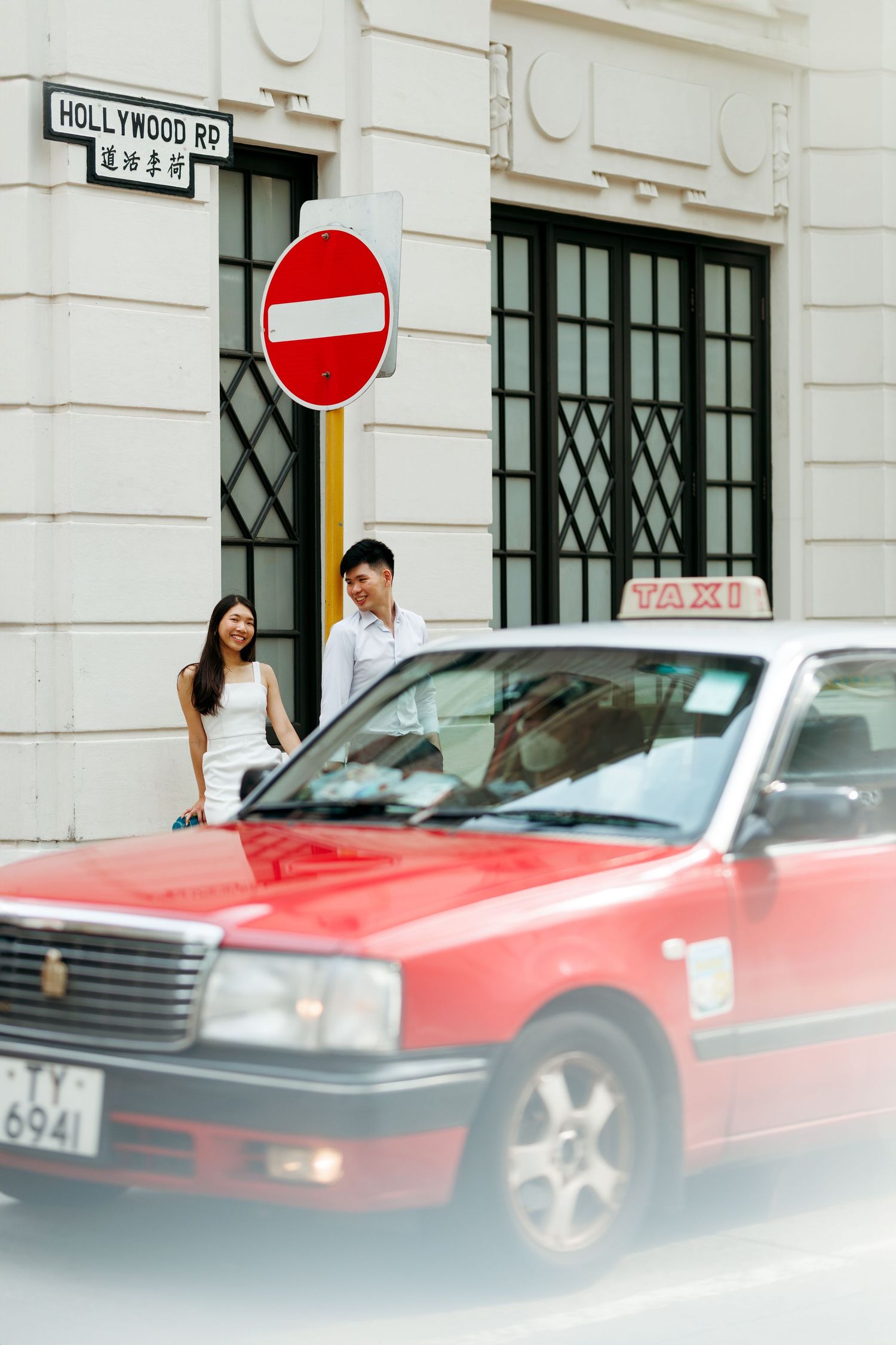 Four sequential photos show a red sports car passing by on a street with Hollywood Road signage visible in the background. Couple Photoshoot