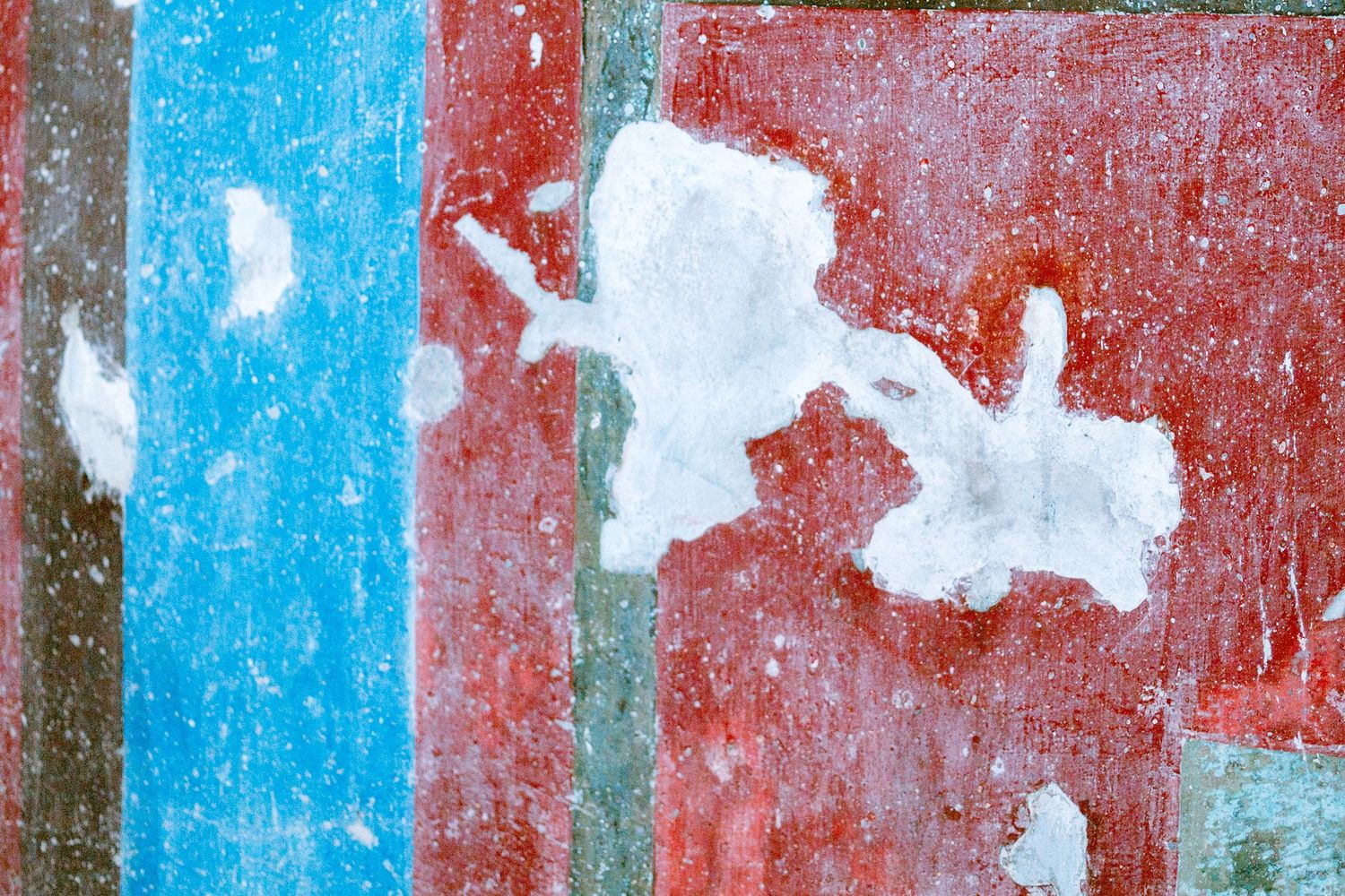 Abstract textured wall surface with peeling paint in bright blue and red colors showing weathered patterns. Taikwun, Hong Kong