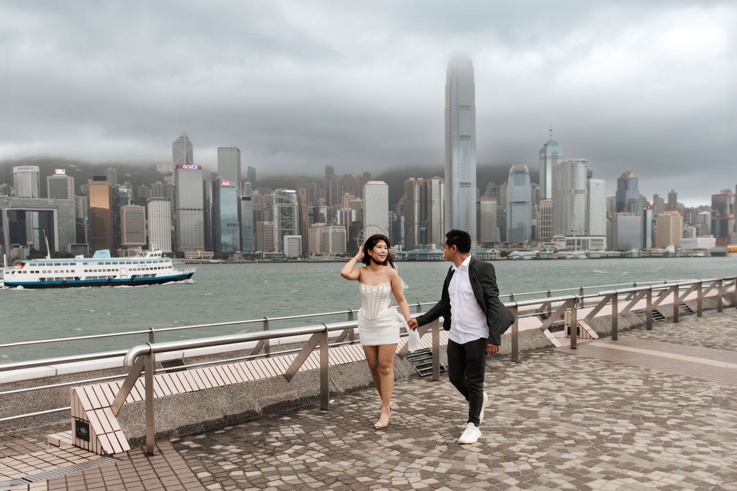 Couple Photoshoot in Hong Kong in TST promenade showing HK skyline