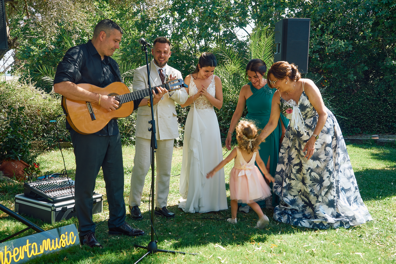 Outdoor wedding ceremony with live musicians and guests in a garden in Barcelona, Spain.