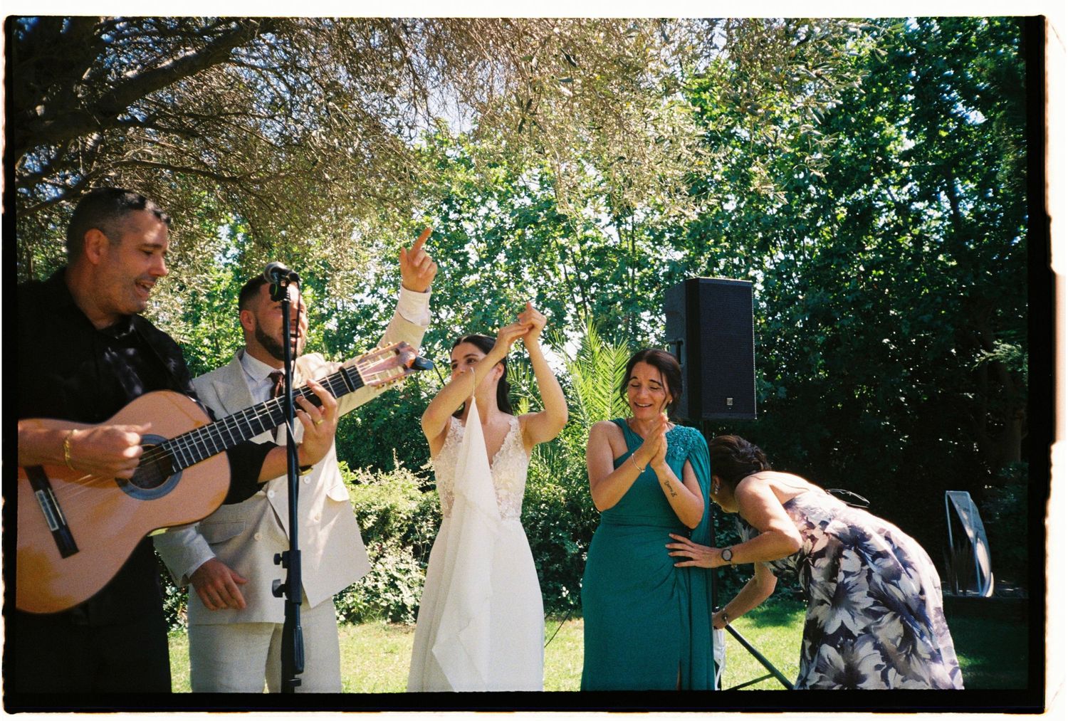 Joyful outdoor wedding ceremony with live musicians and guests celebrating in Barcelona, Spain.