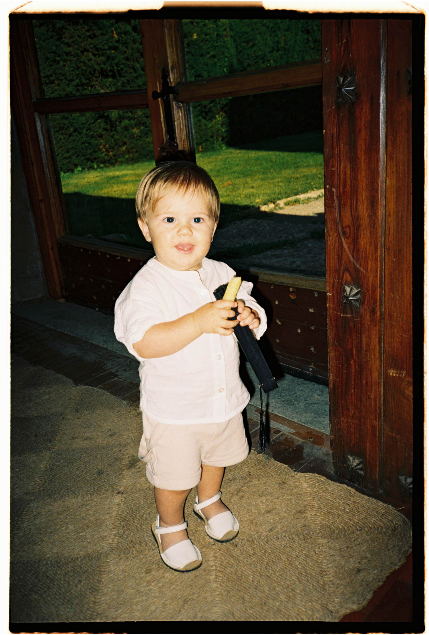 Candid film photograph of a young wedding guest during an outdoor Barcelona wedding celebration.