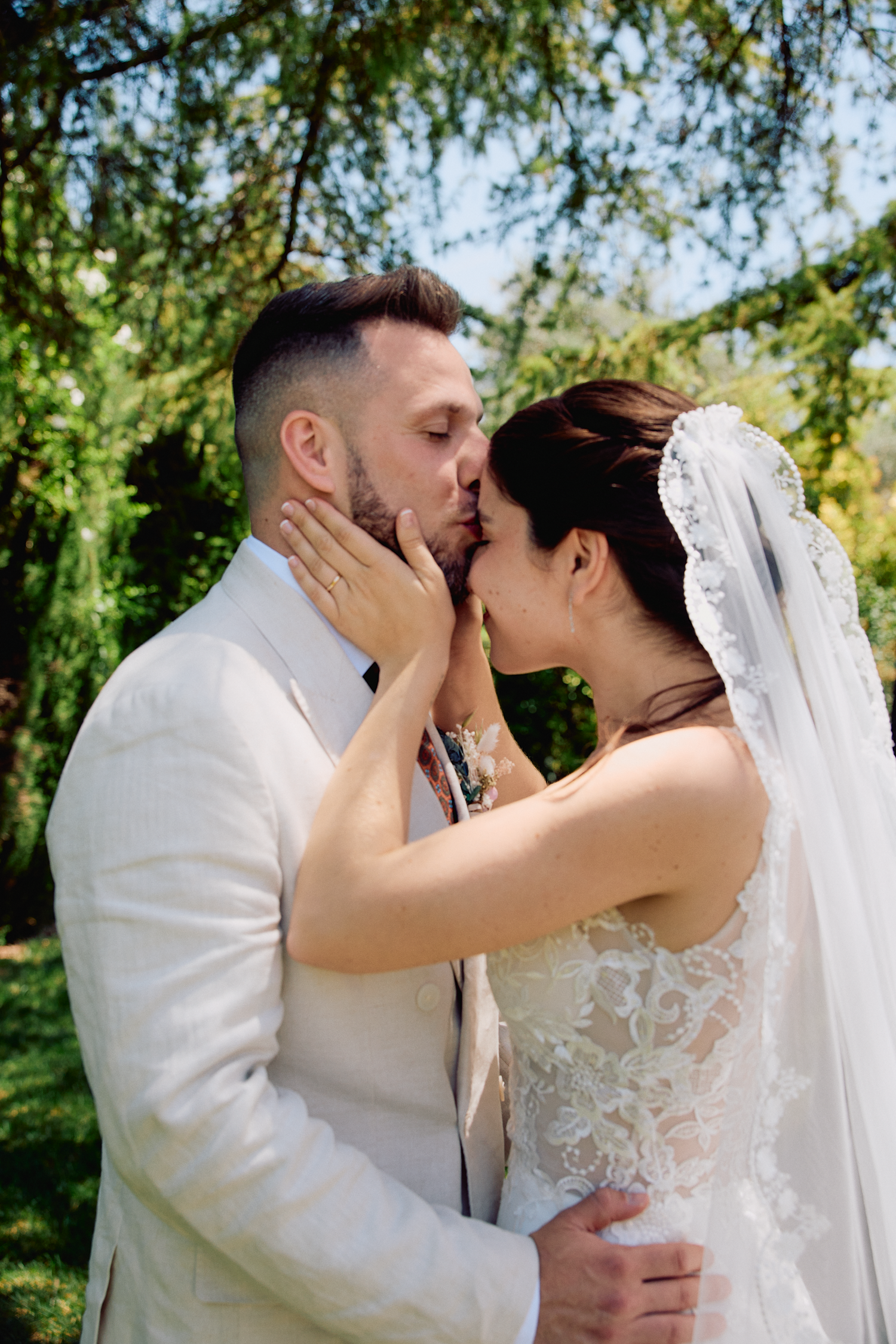 Bride and groom sharing a kiss during their outdoor wedding celebration in Barcelona, Spain.