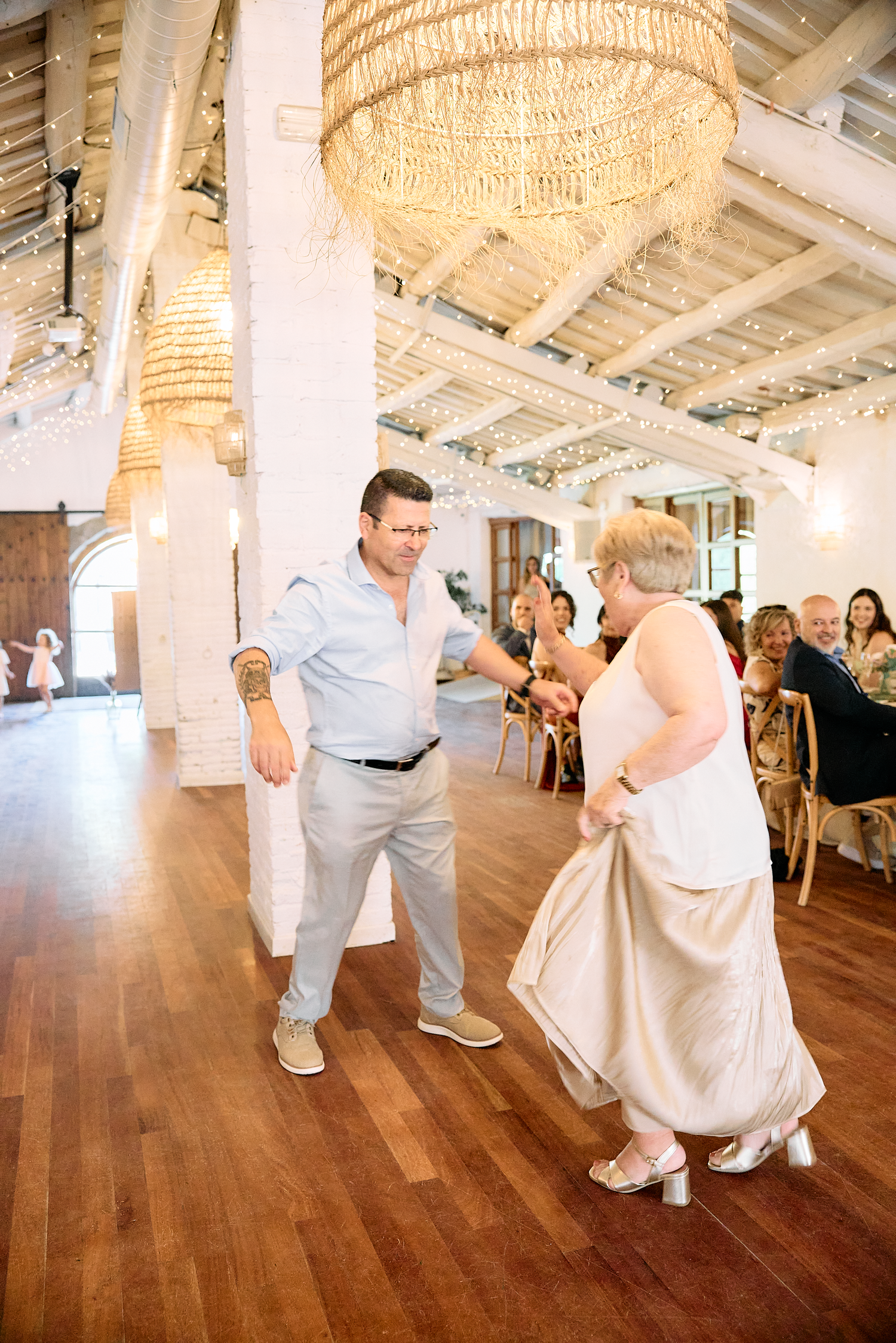 Candid photograph of wedding guests dancing together during a lively Barcelona reception.
