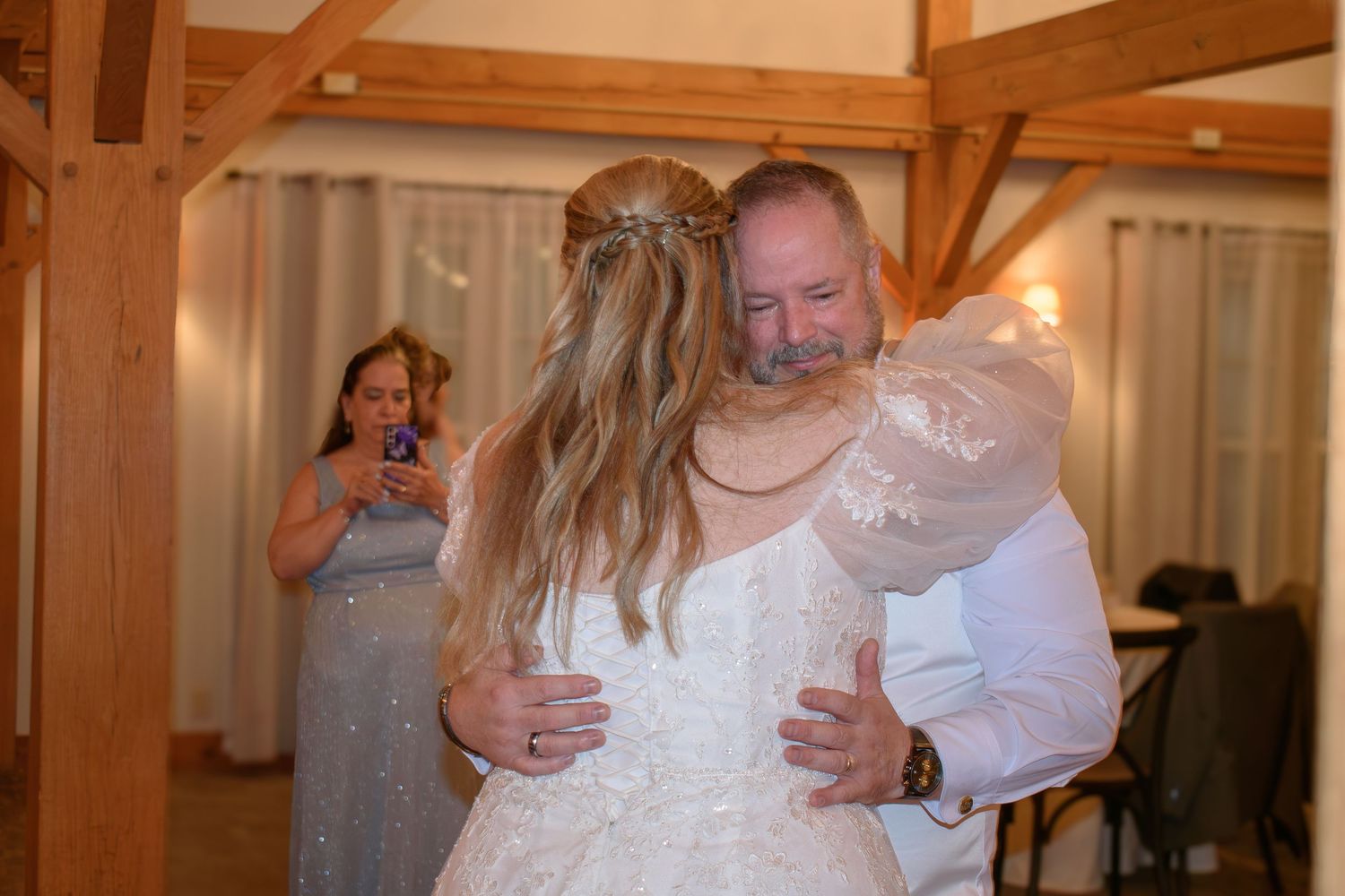 Bride and groom share an emotional first dance embrace at The Barn at Wight Farm, Sturbridge, MA with a guest photographing in background.