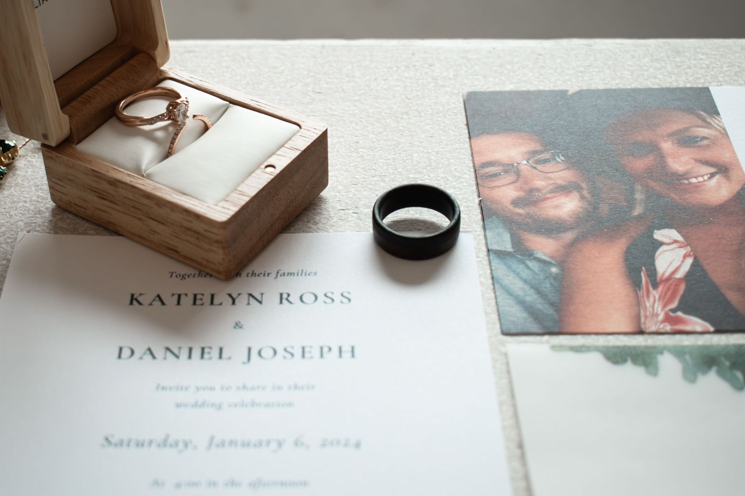 Wedding flat lay with gold ring box, black band, invitation for Katelyn Ross and Daniel Joseph.
