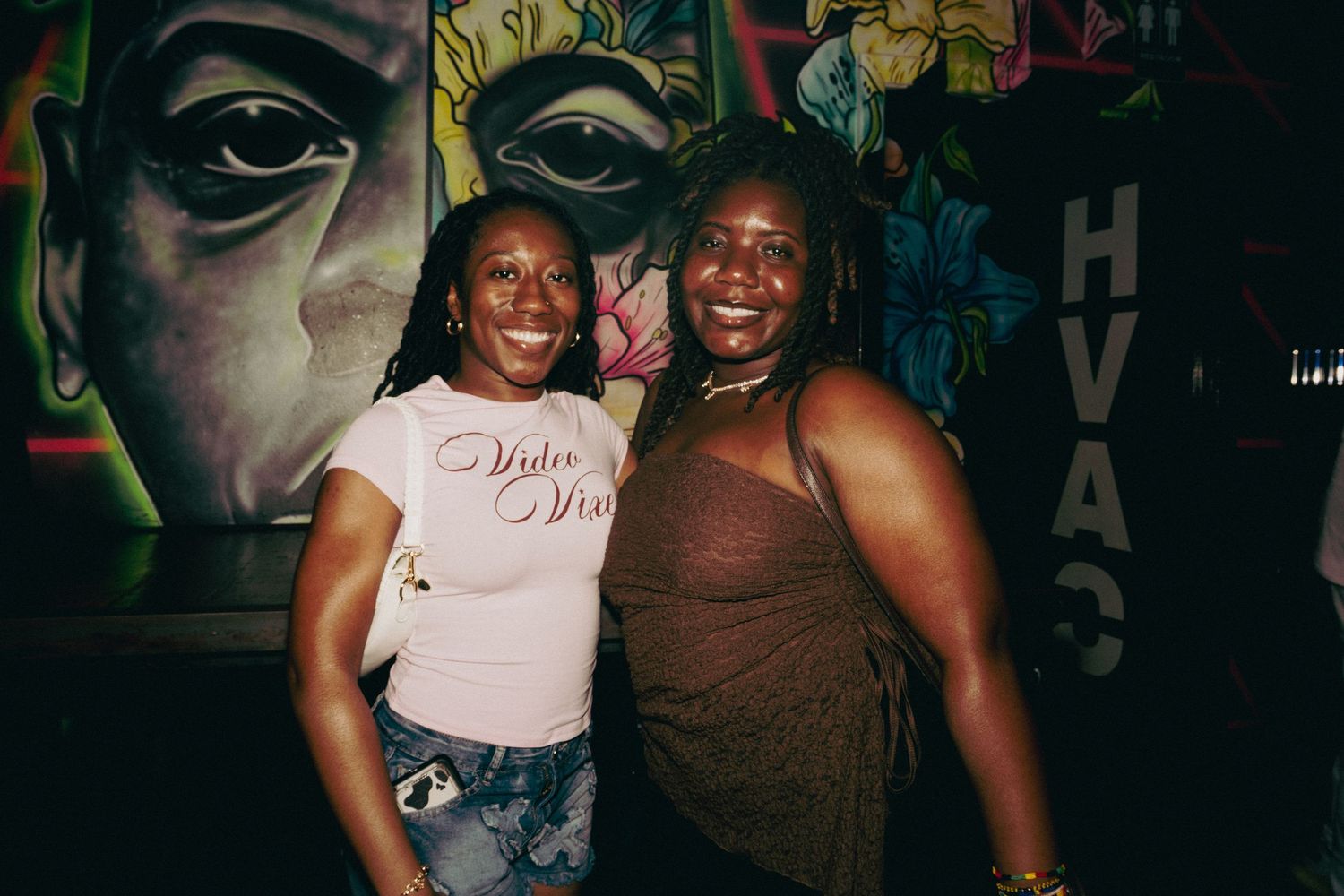 Friends enjoying a night out at what appears to be a bar or club in a dimly lit setting.