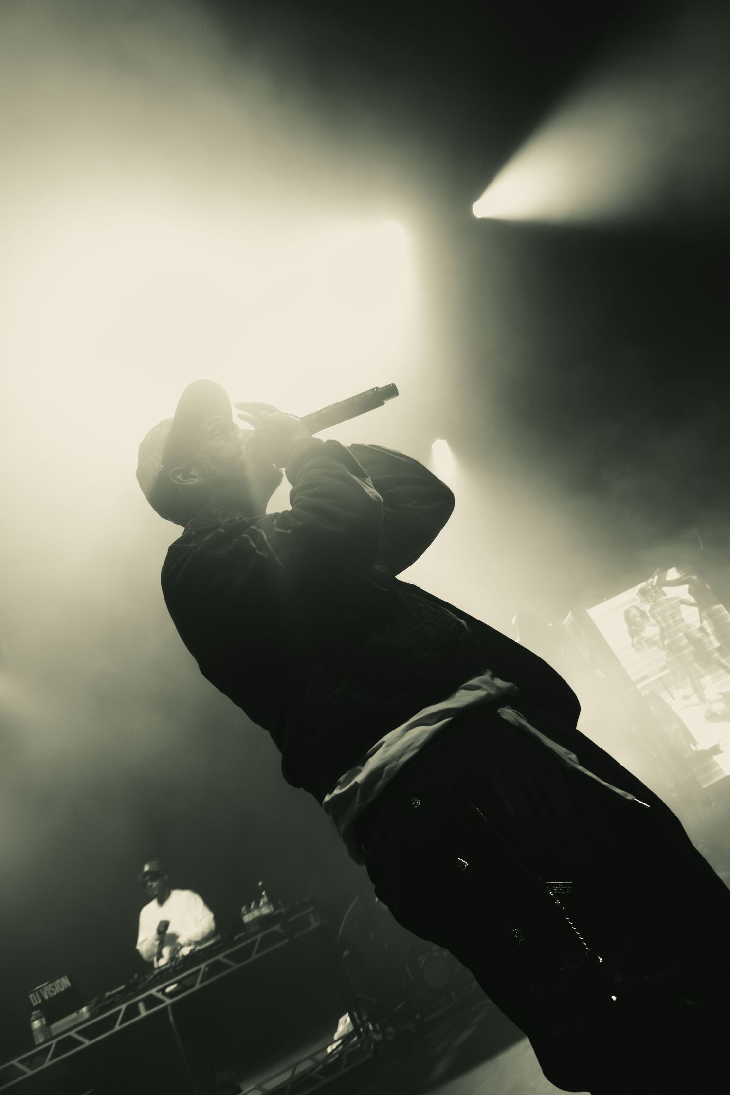 Silhouetted performer on stage with moody backlighting creating a dramatic atmosphere.