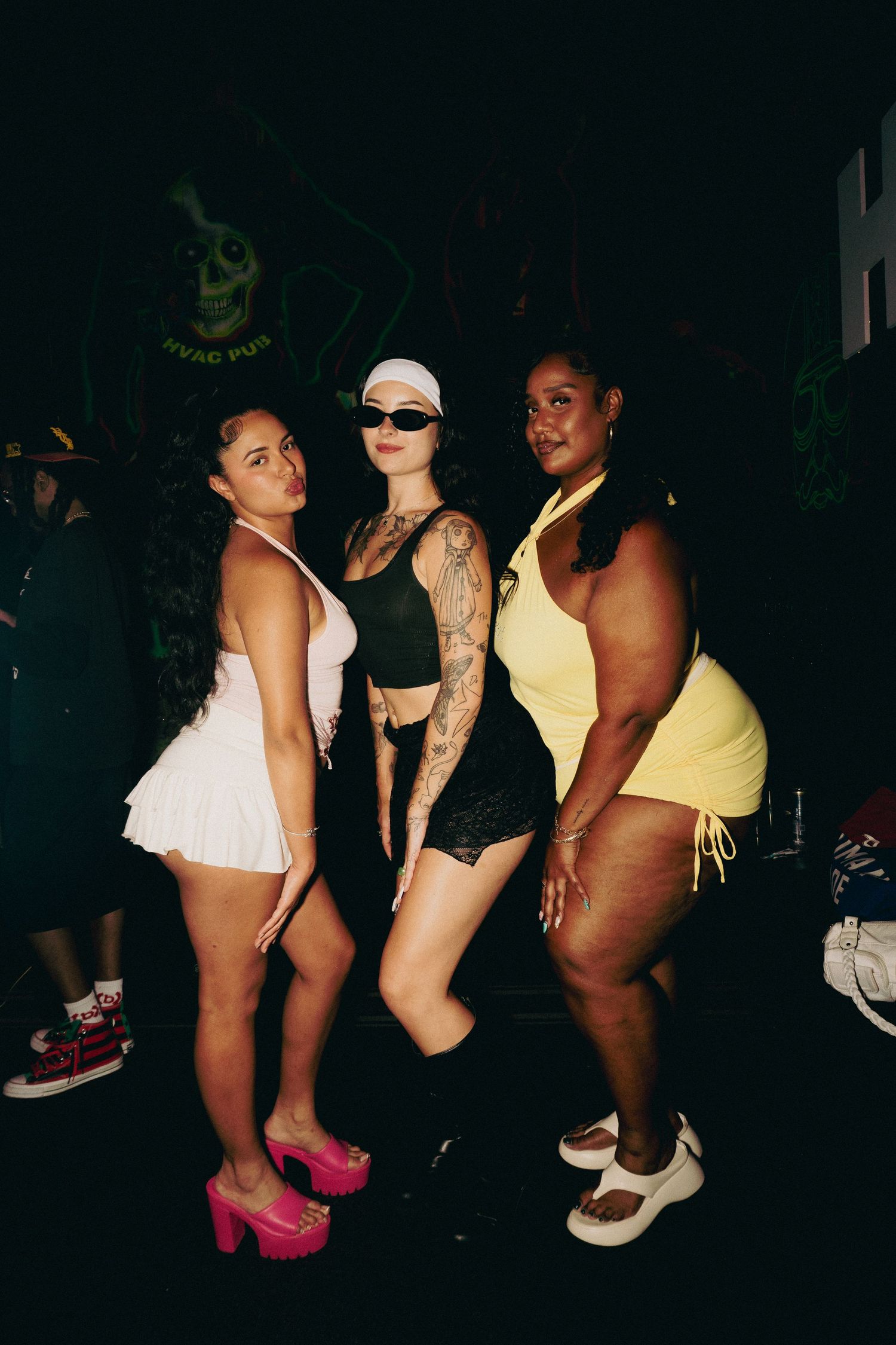 Silhouettes of dancers in colorful outfits at a nightclub.