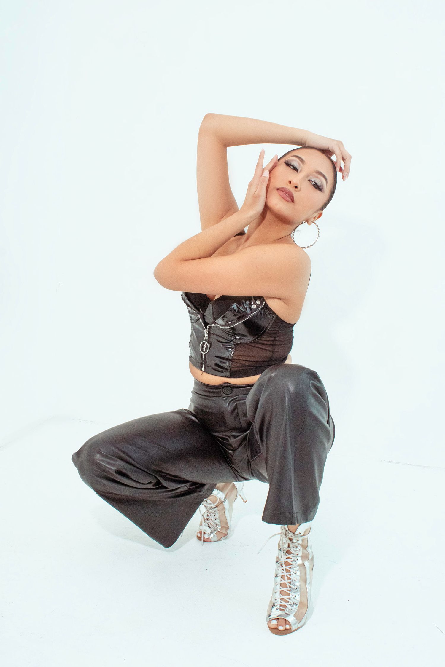 Fashion model in leather pants strikes dynamic poses against white background.
