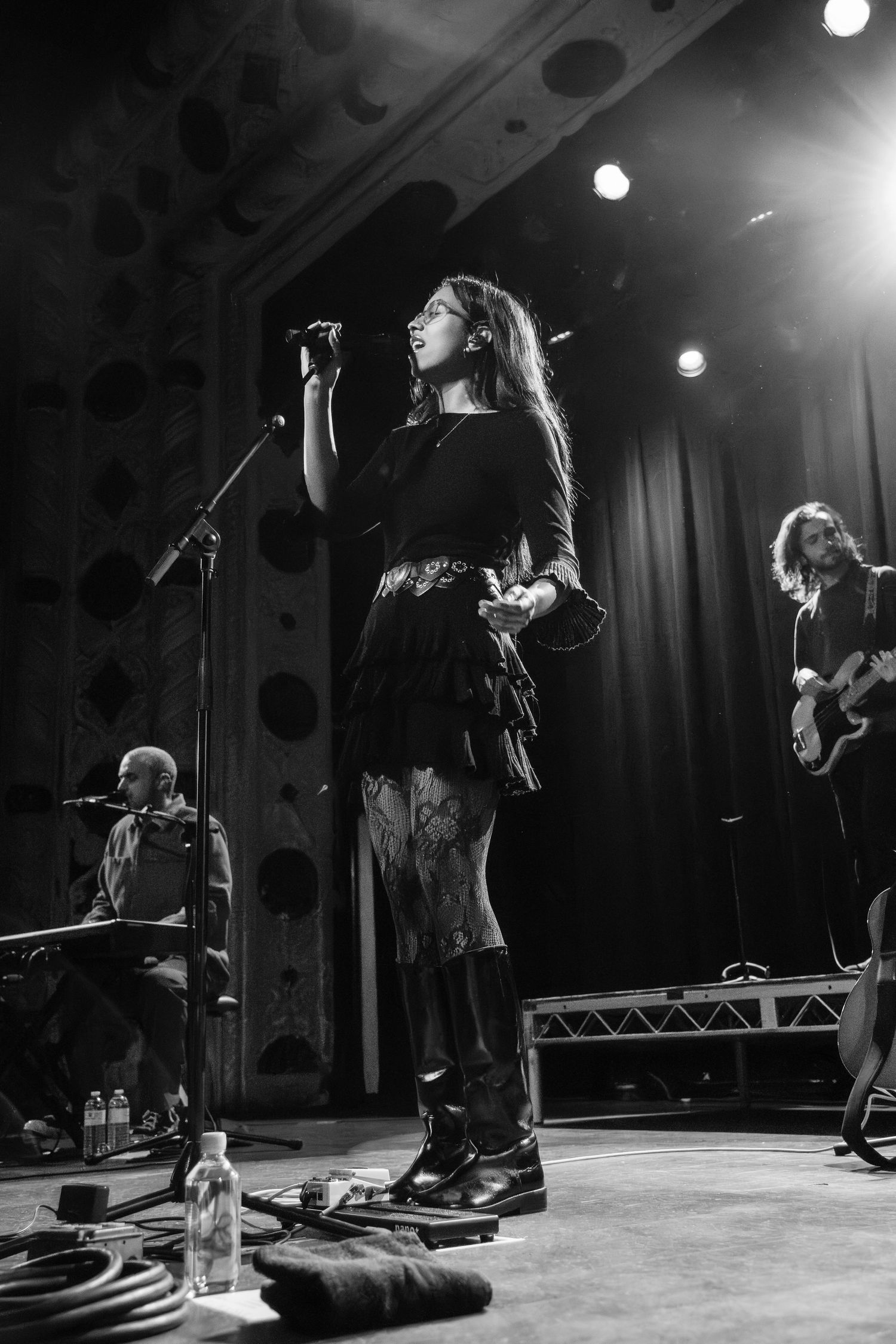 Black and white concert photos showing performers on stage with dramatic lighting and microphone stands.
