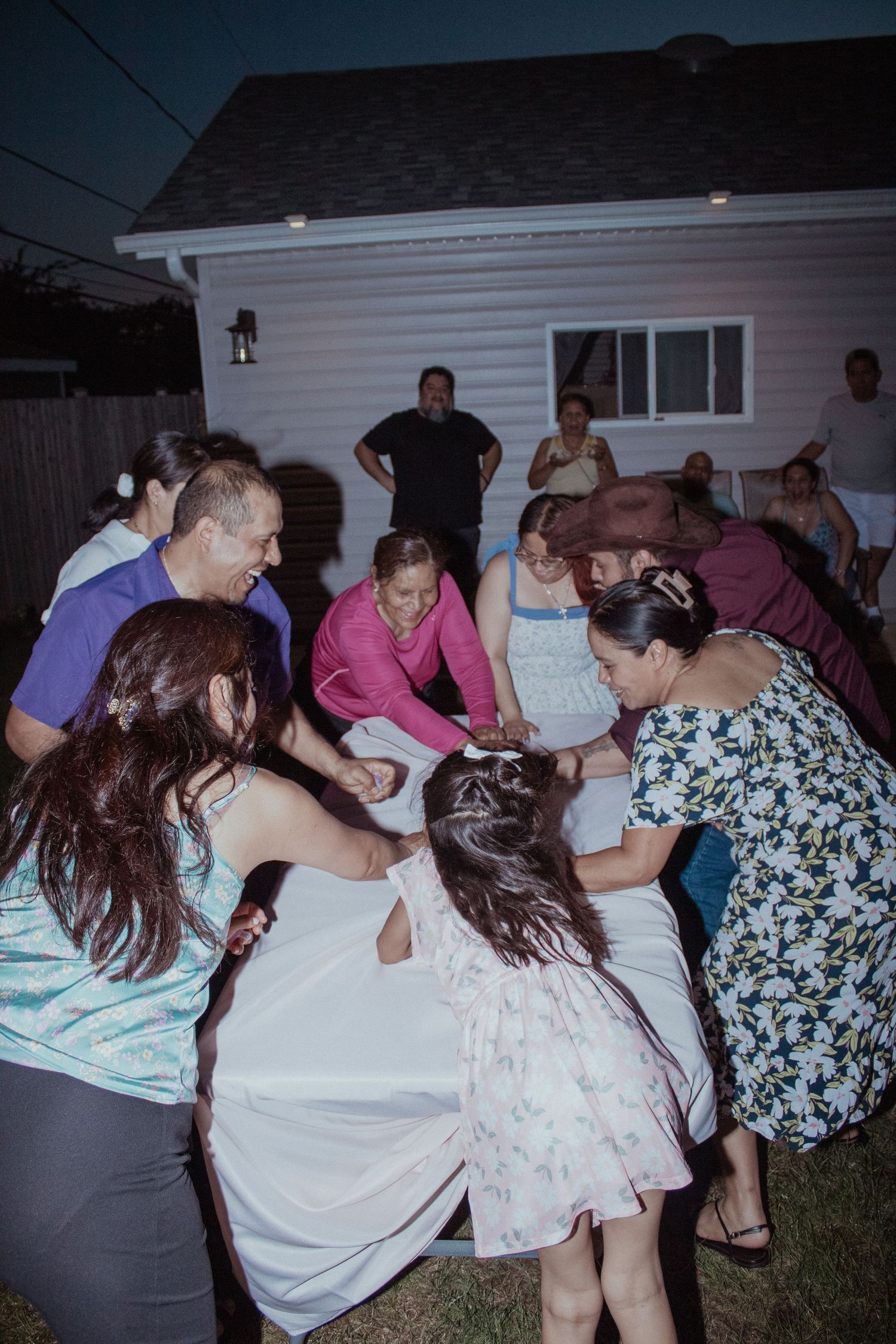 Group of party guests dancing and celebrating at a nighttime outdoor gathering.