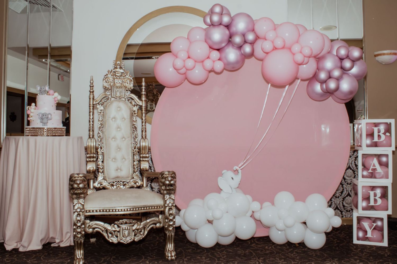 Pink and white balloon arch decorations at a baby shower event.