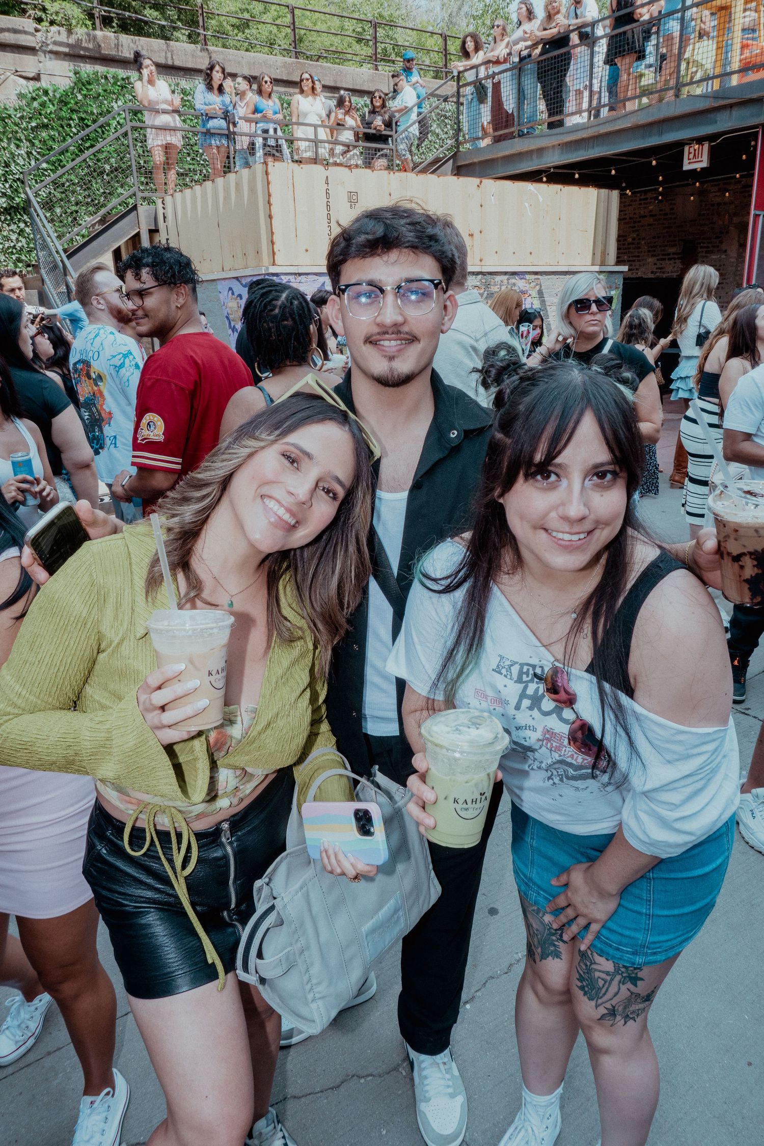 Friends enjoying drinks and posing together at an outdoor summer event.