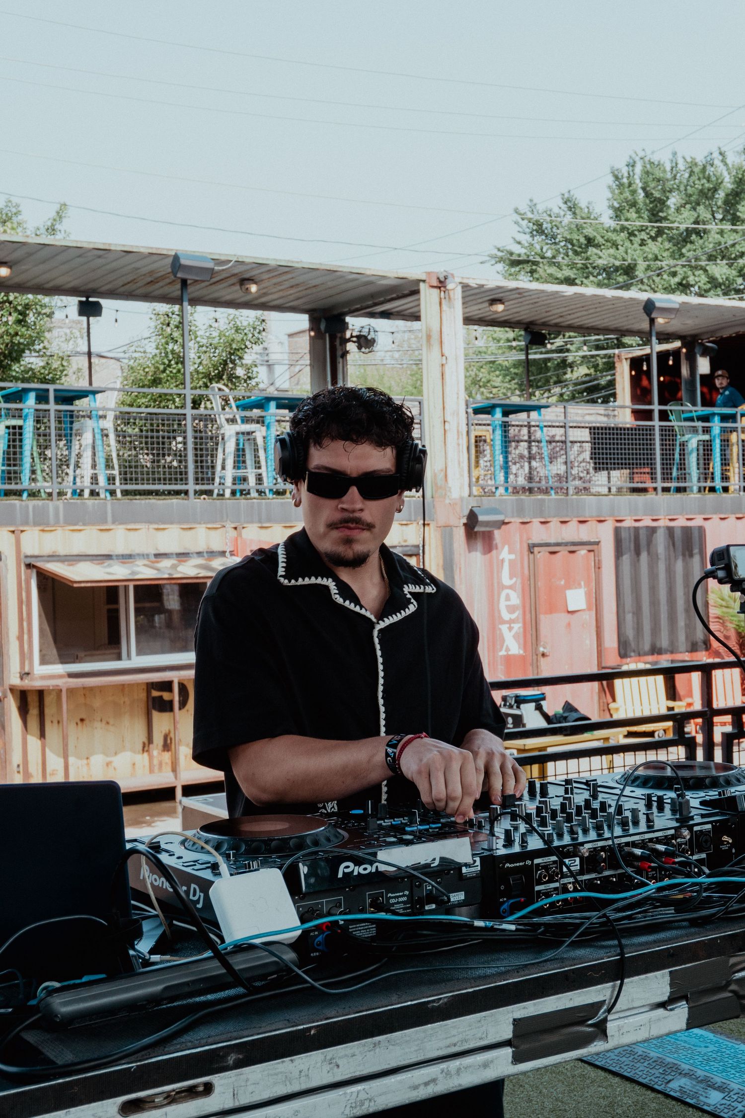 DJ working at outdoor event with professional equipment setup.