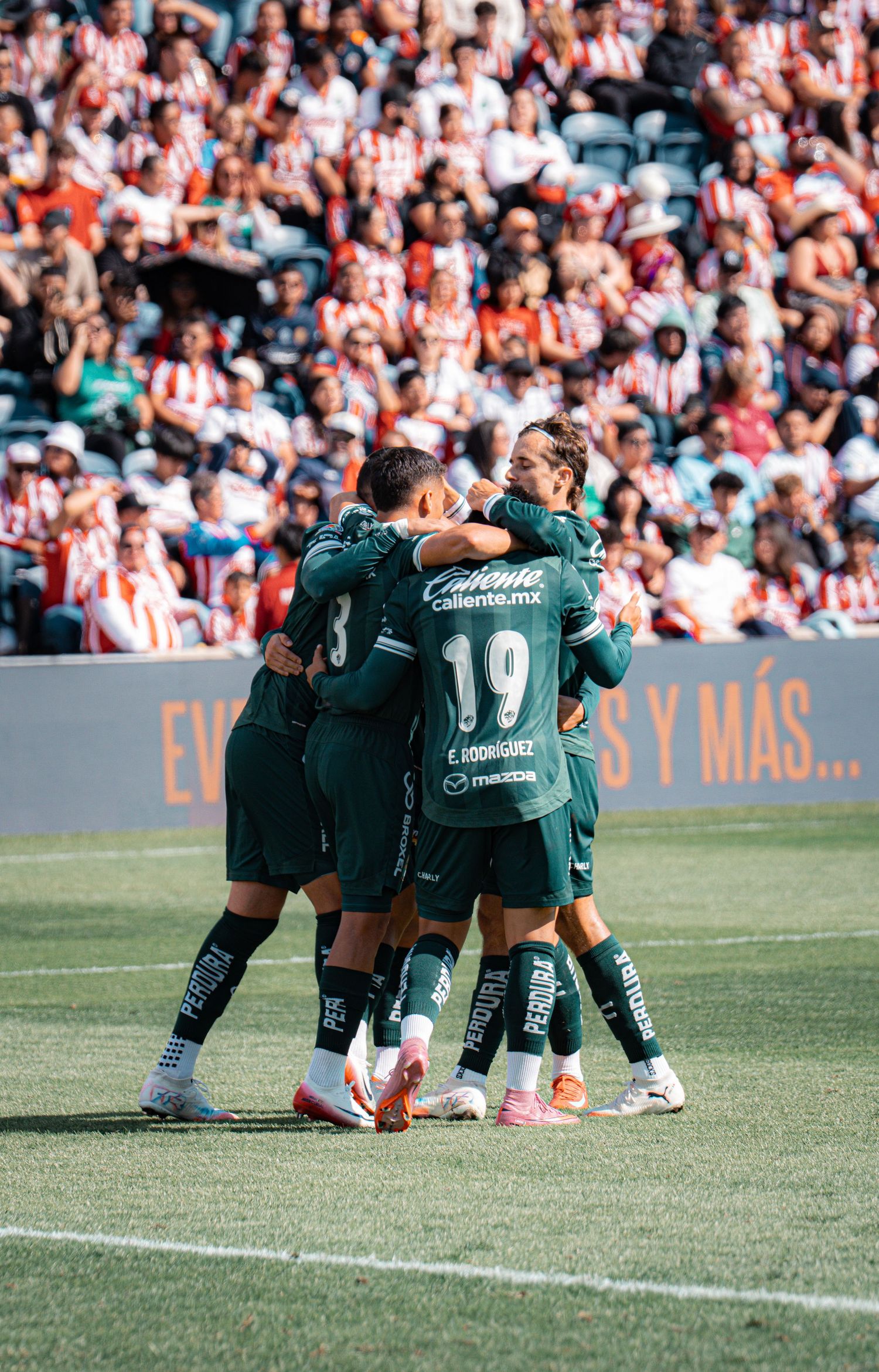 Soccer players huddle together on the field during a match.